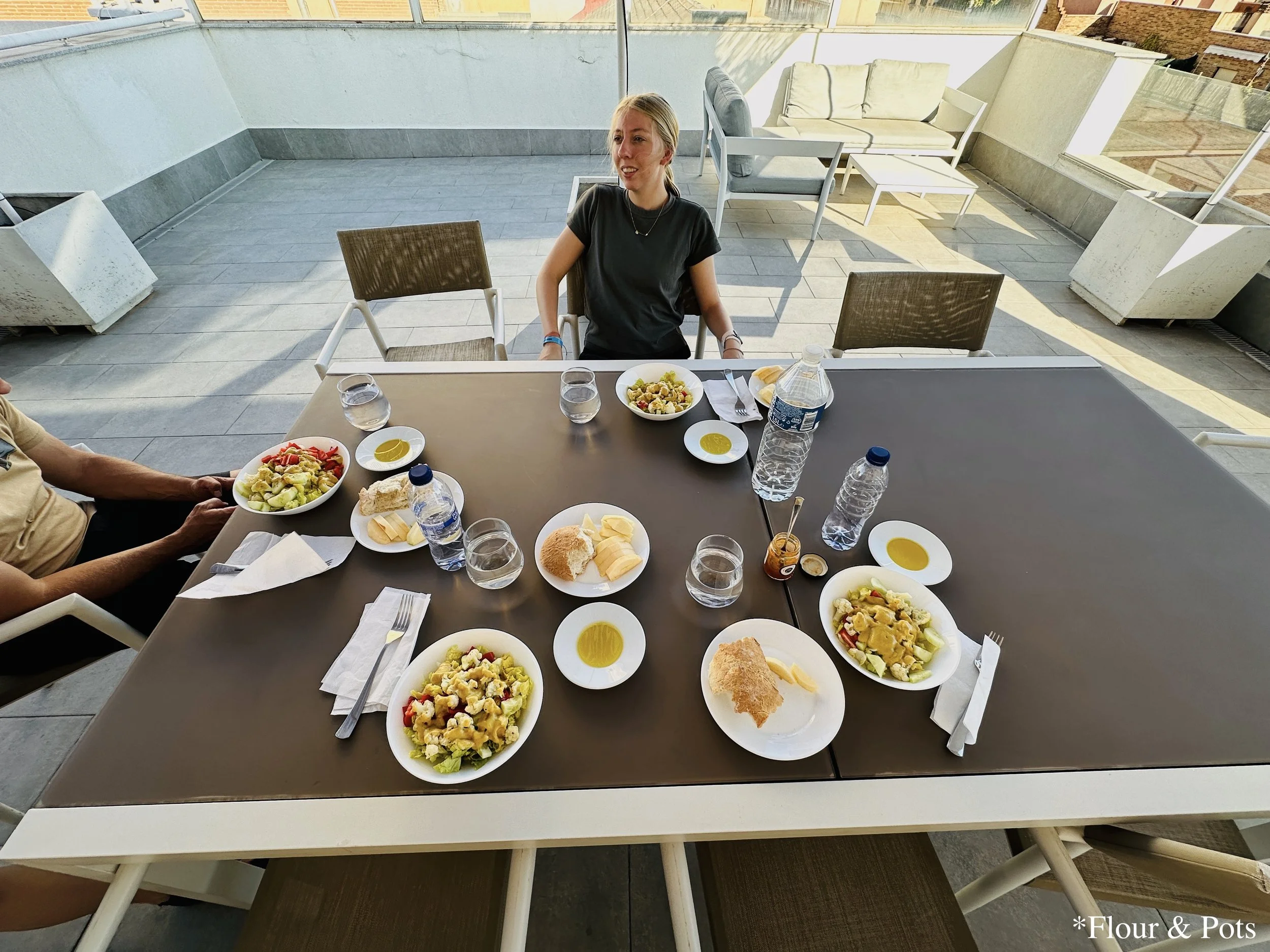 Outdoor dinner under the covered patio of our Airbnb in Madrid, Spain, featuring veggie and honey mustard salads served in a relaxed, warm evening setting.