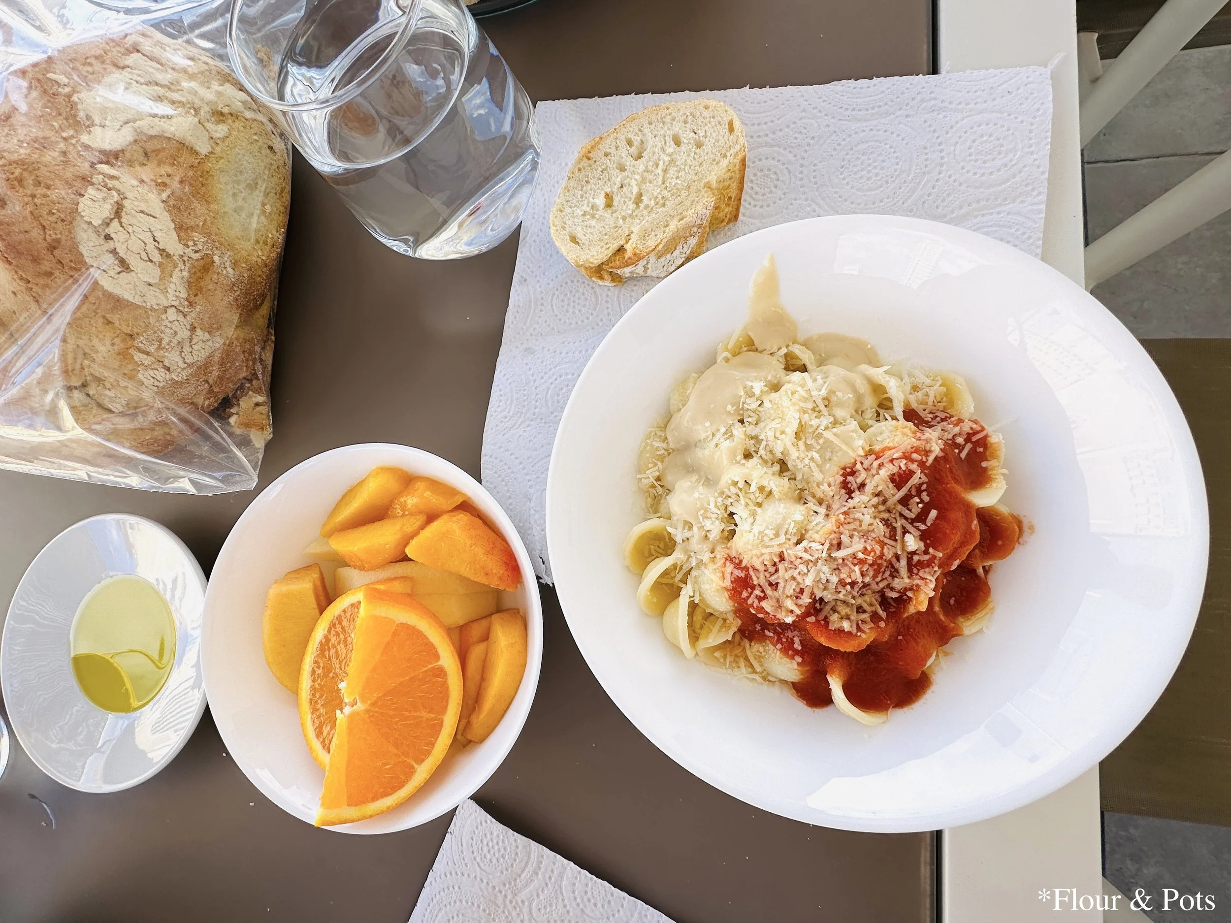 A cozy pasta dinner with bread and fruit served on the patio of an Airbnb in Madrid, Spain.