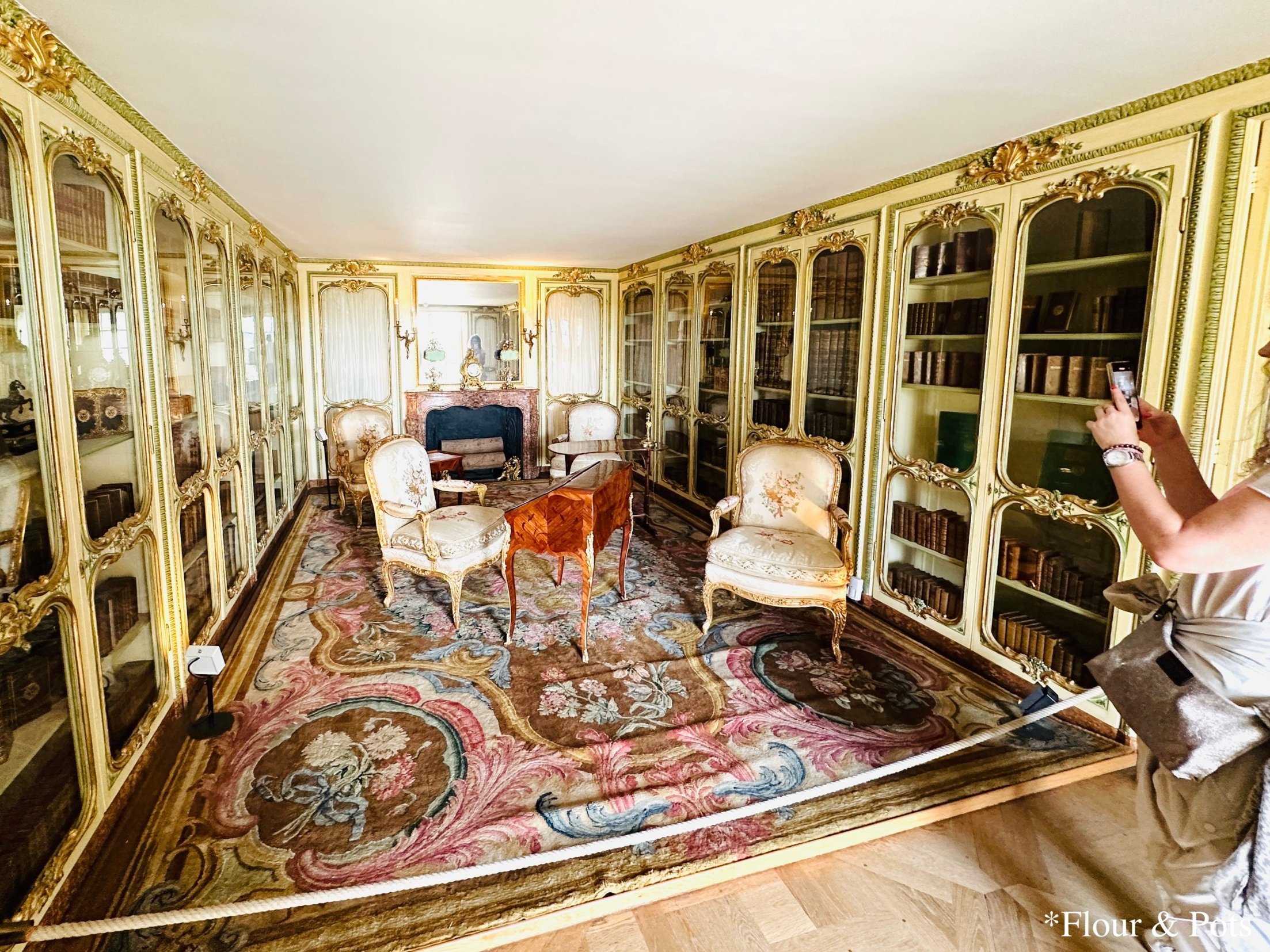 Cozy and quaint library room inside the Palace of Versailles with classic wooden shelves and elegant decor.