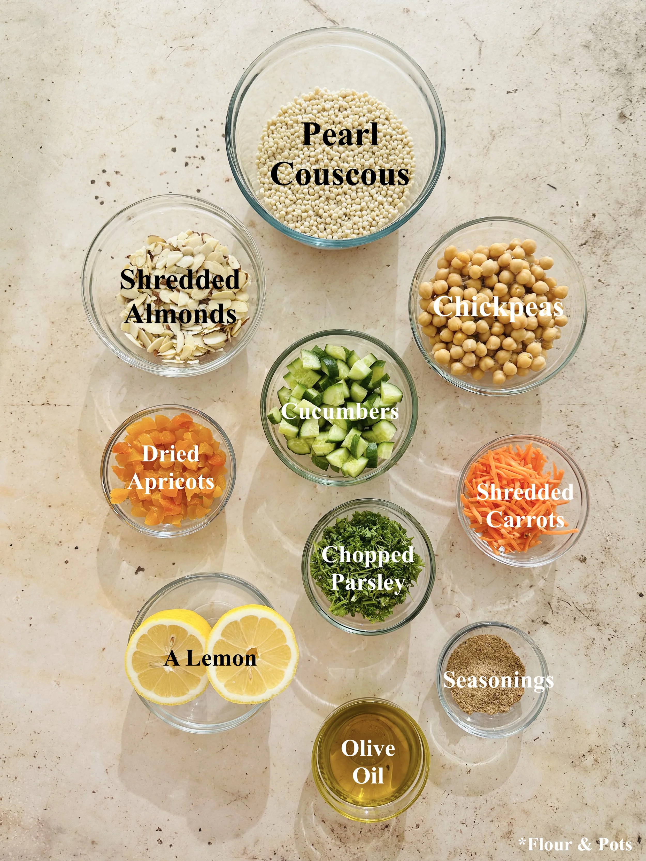 Ingredients for couscous salad: pearl couscous, chickpeas, cucumbers, almonds, apricots, carrots, and parsley