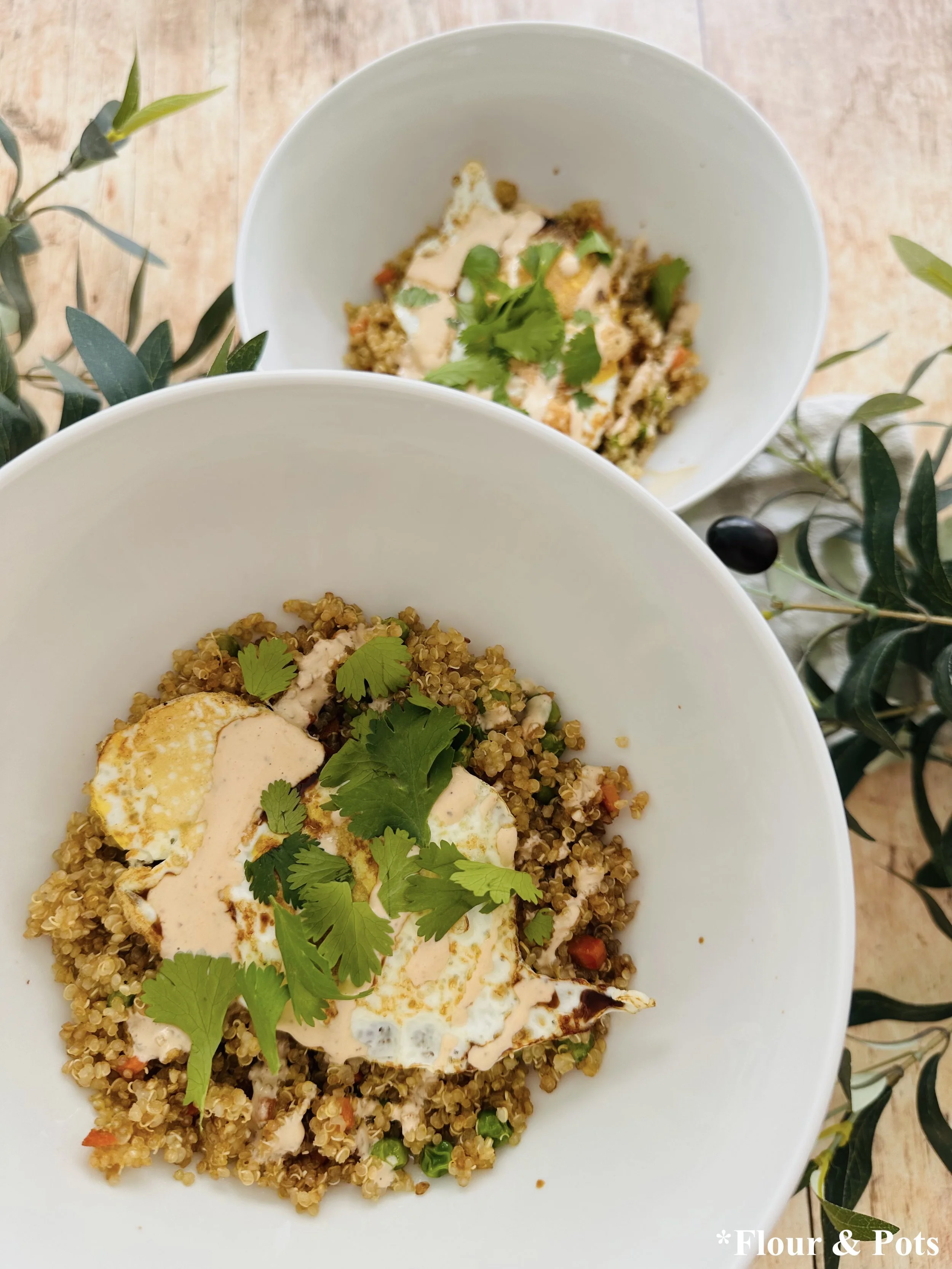 High-protein savory breakfast bowl with quinoa, eggs, and honey sriracha drizzle