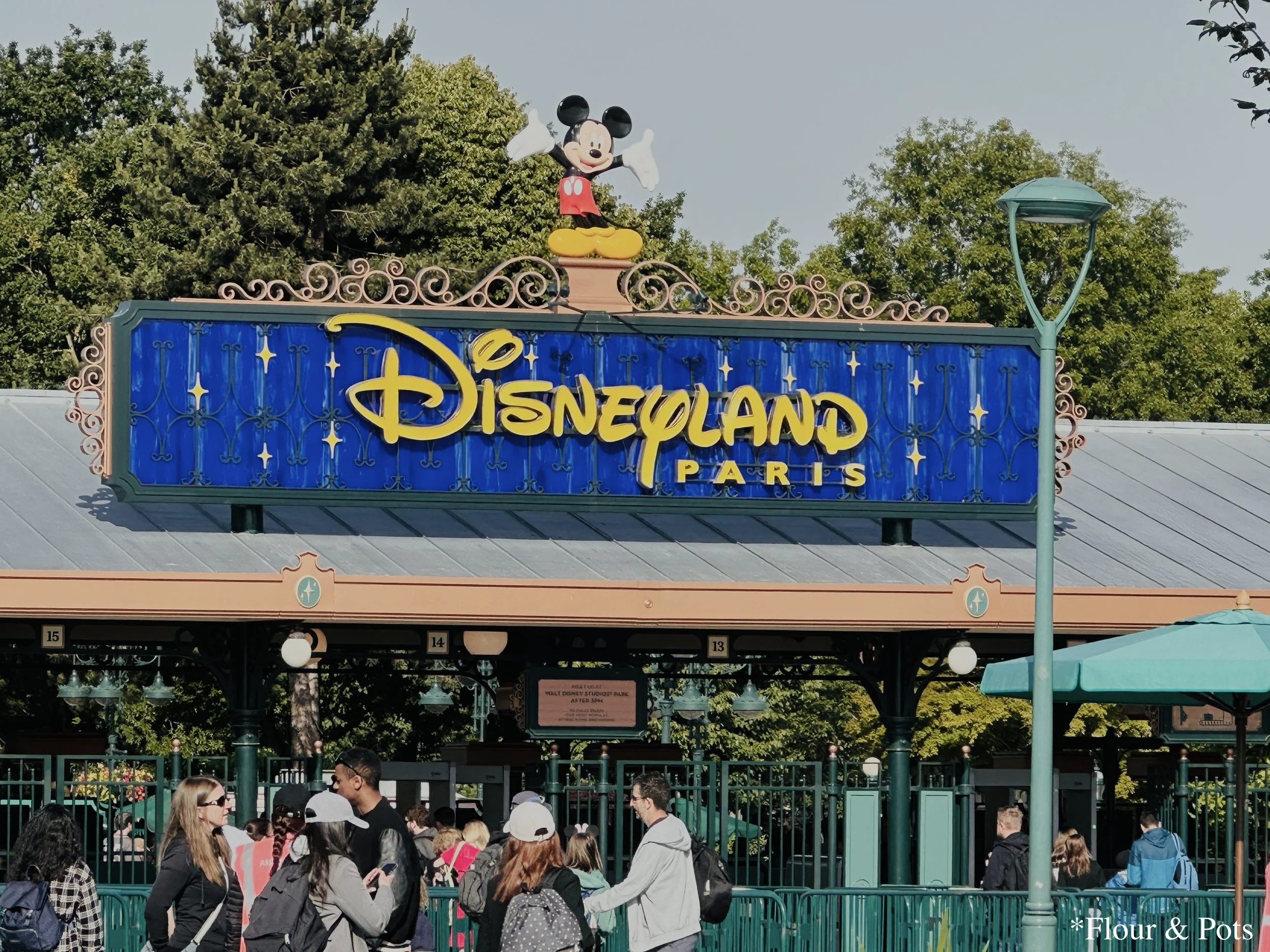 The entrance sign for Disneyland Paris, located just before the security checkpoint, welcoming guests to the park.