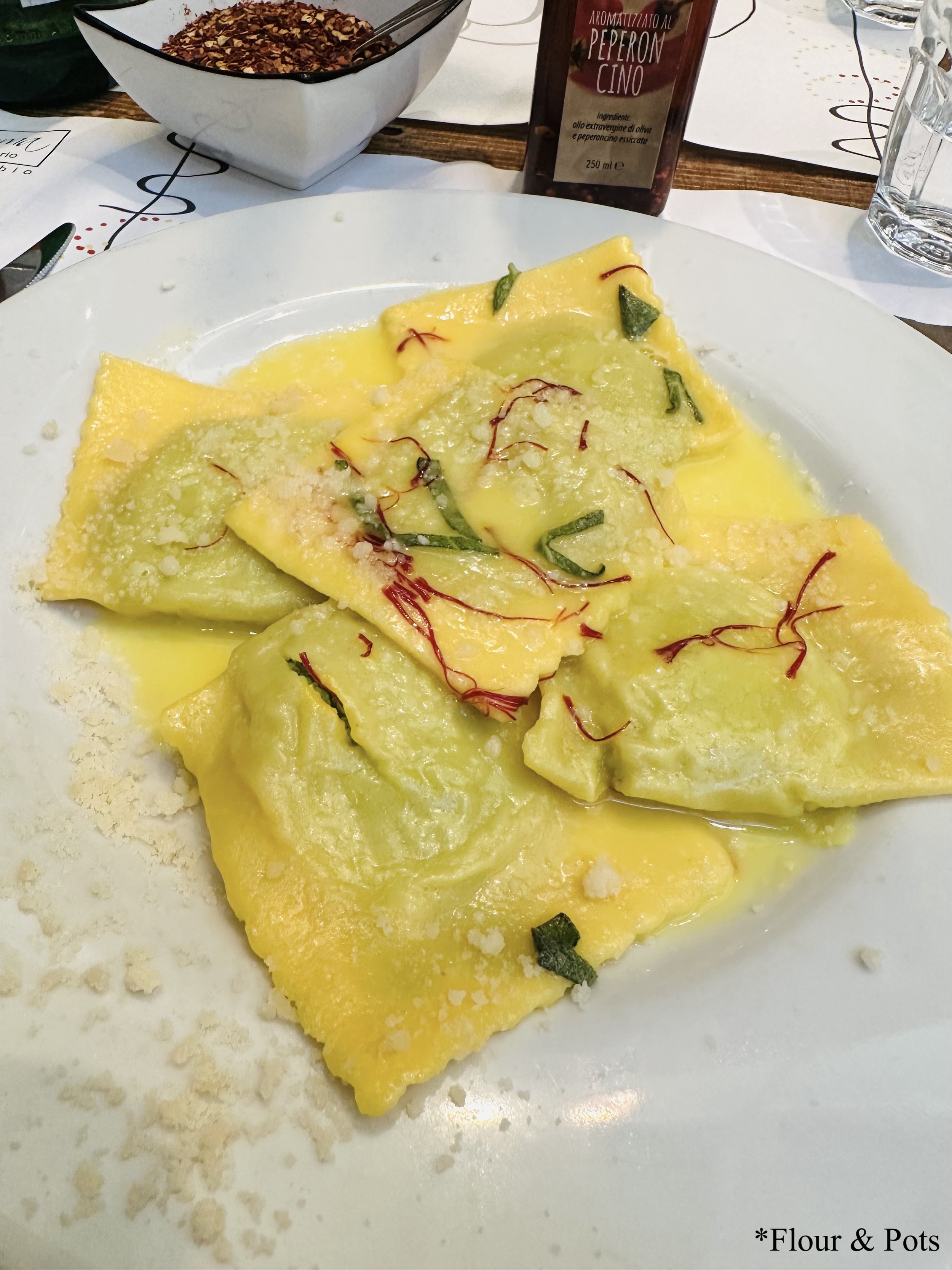 Homemade lemon cheese–filled ravioli with saffron sauce from Emma in Rome, Italy, beautifully plated and bursting with rich, zesty flavor.