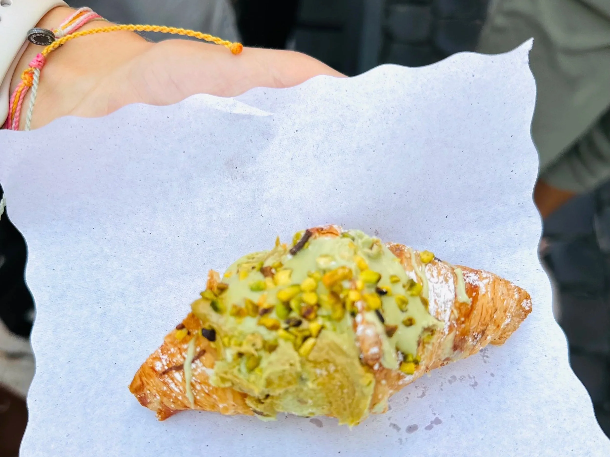 Pistachio-stuffed croissant enjoyed near the Trevi Fountain in Rome, Italy.