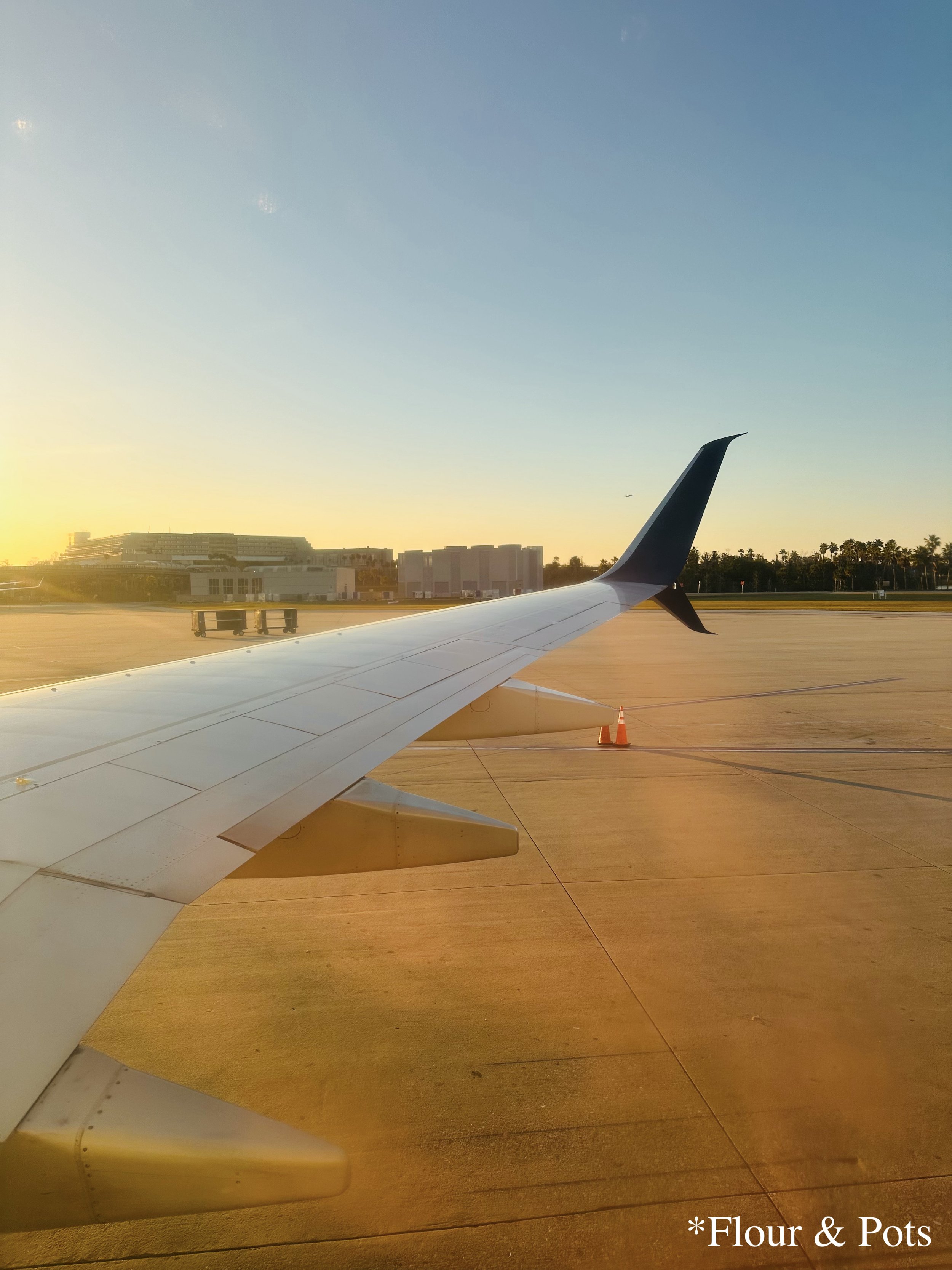 Airplane on the runway at Orlando International Airport (MCO) ready for takeoff to Salt Lake City (SLC) during sunset.