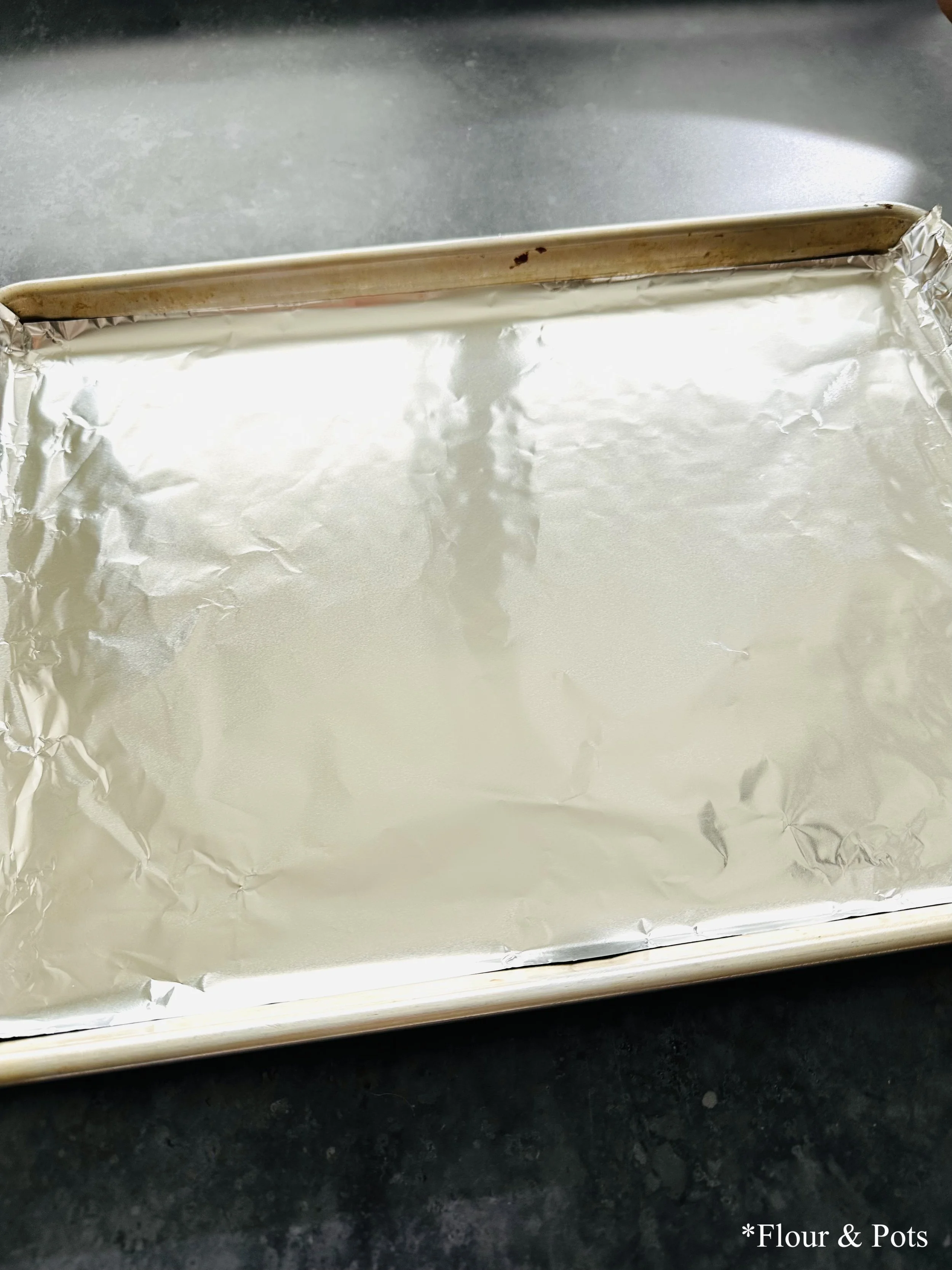 A sheet pan lined with foil, ready for roasting poblano peppers.