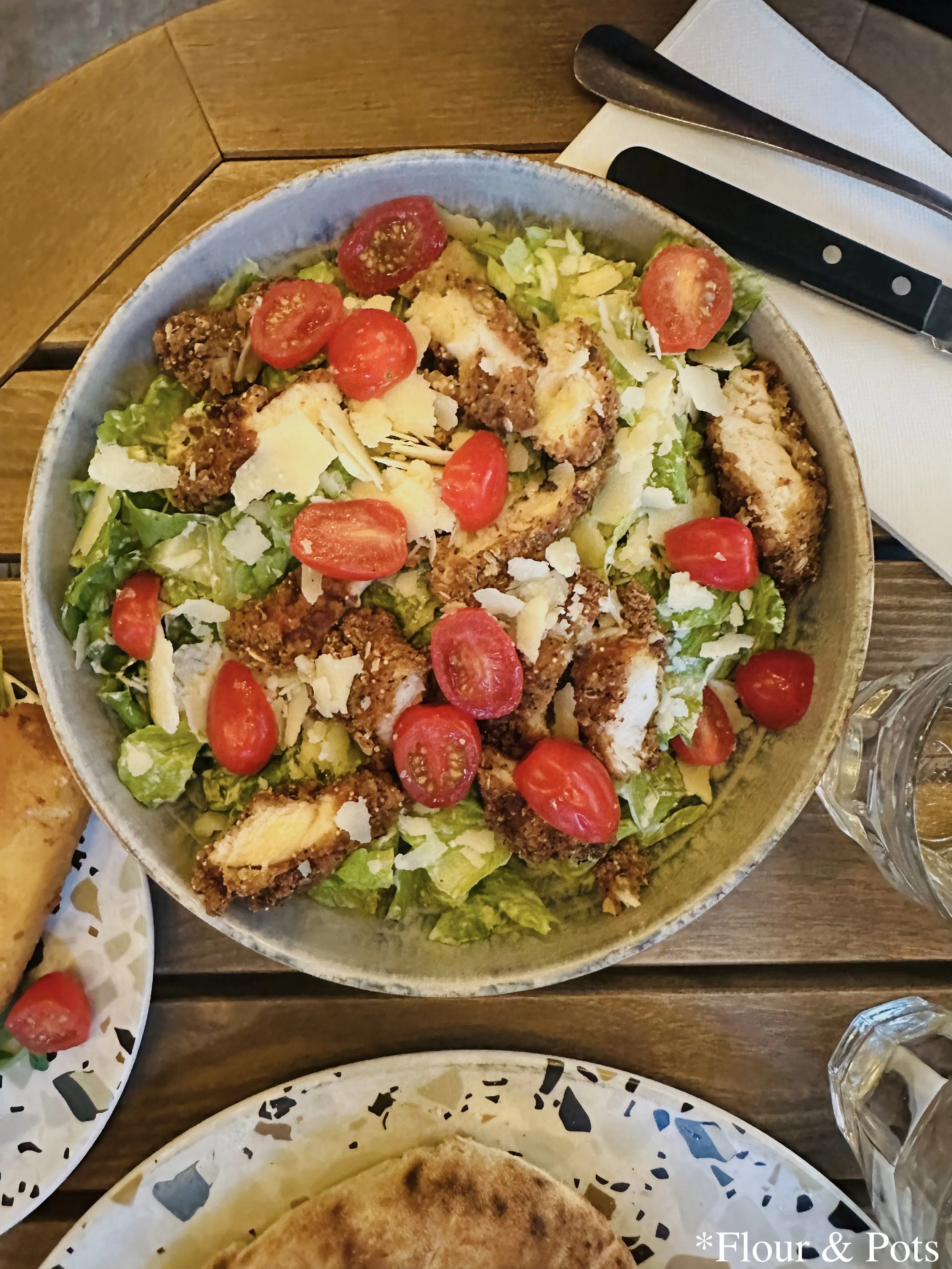 Crispy chicken Caesar salad with cherry tomatoes from Bianca restaurant in Paris, France.