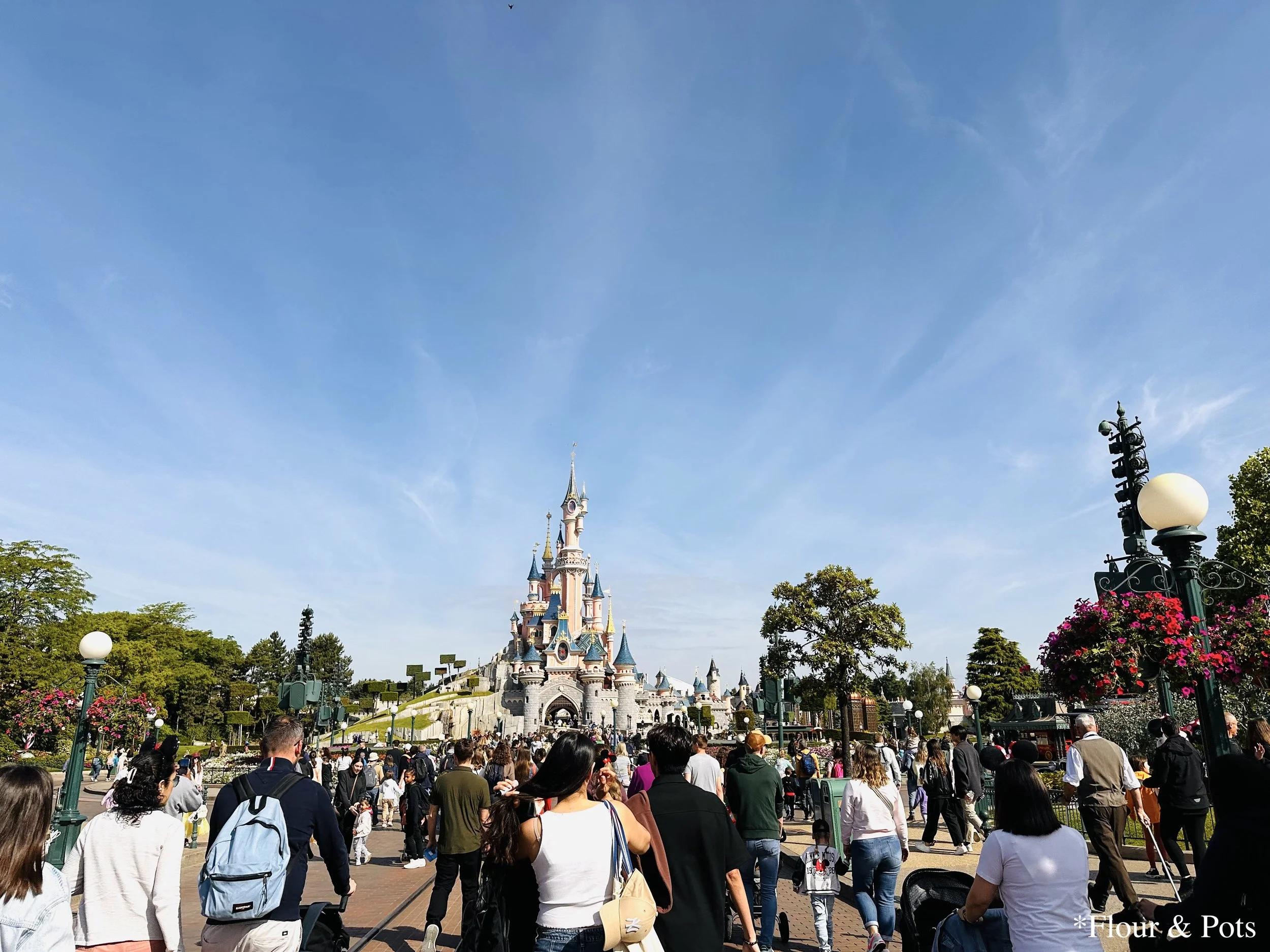 The iconic Disneyland Paris castle viewed from Main Street, beautifully illuminated and framed by charming park details, capturing the magical atmosphere of the park.
