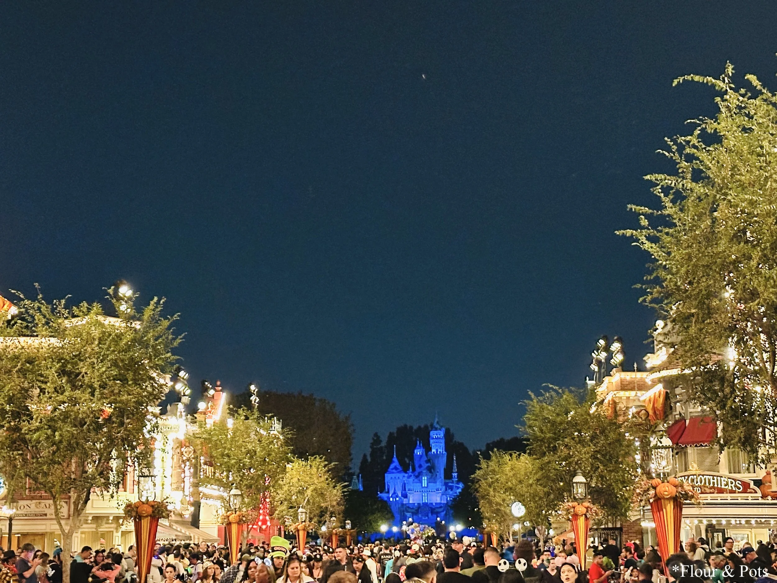Halloween night on Disneyland’s Main Street with festive lights and decorations.