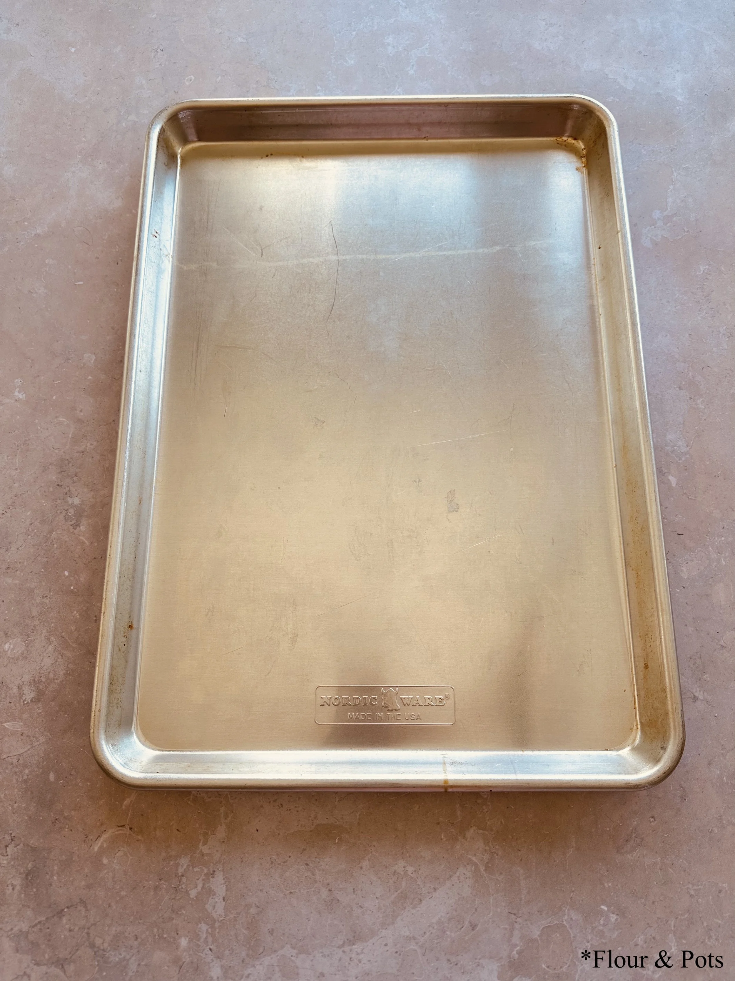 Step 3: A baking sheet being pulled out, ready for use in the peach freezing process.