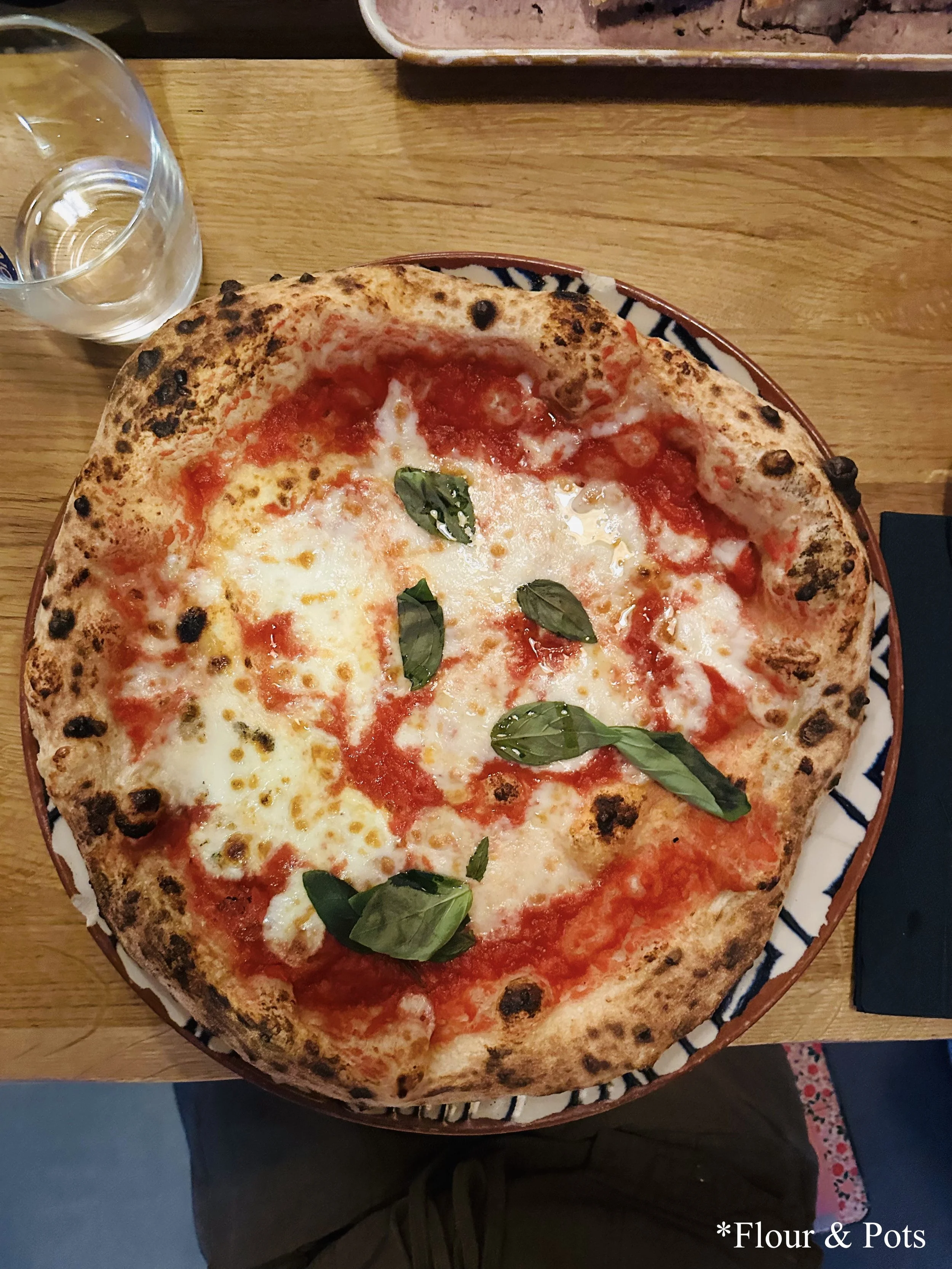Delicious Margherita pizza from Grazia Pizza Napoletana in Munich, Germany, topped with fresh tomato sauce, Fior di Latte cheese, basil, and a drizzle of olive oil.