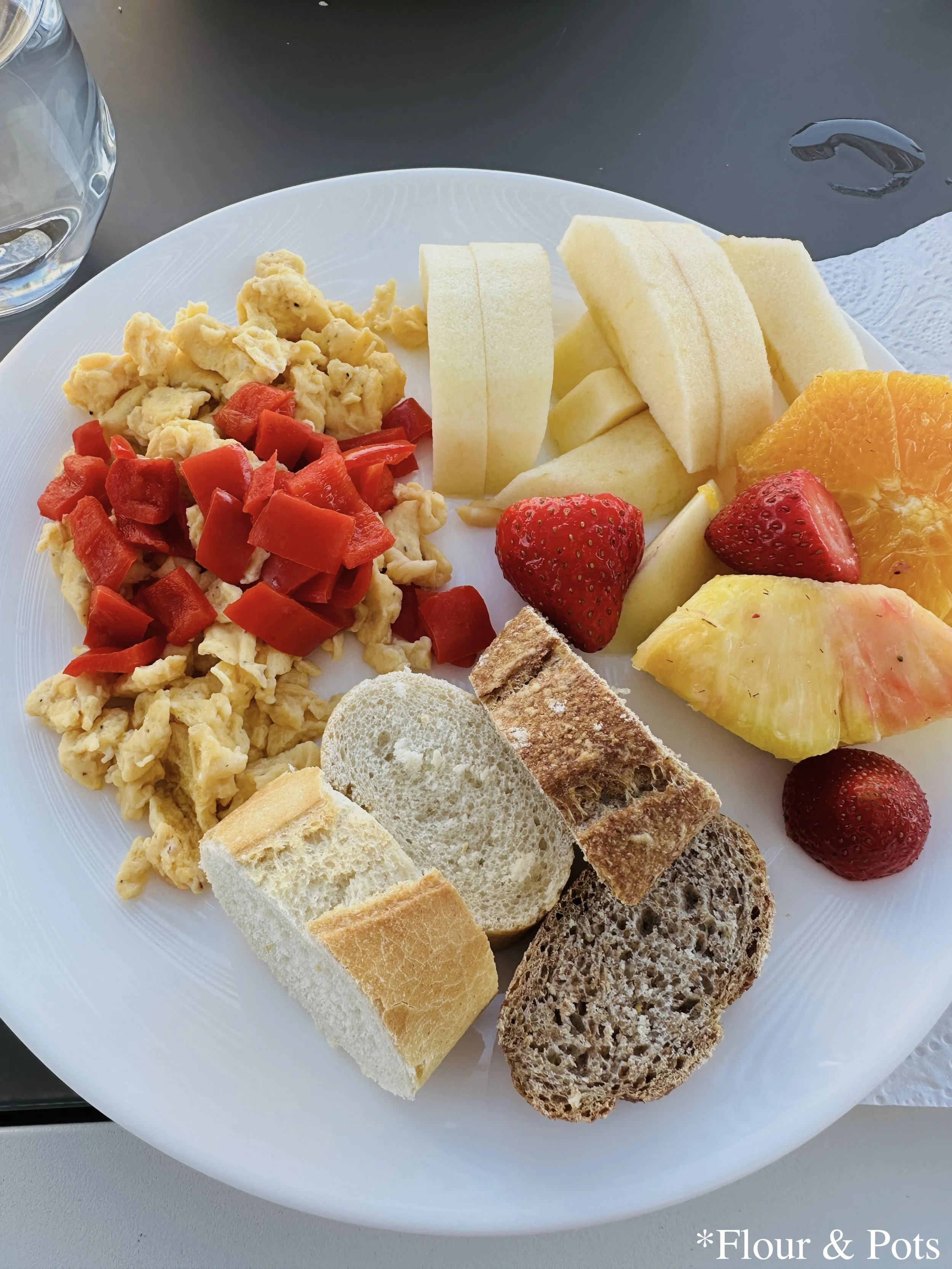 A homemade scrambled egg dinner at our Airbnb in Madrid, Spain, served with fresh fruit from a local market, creating a simple and delicious meal.