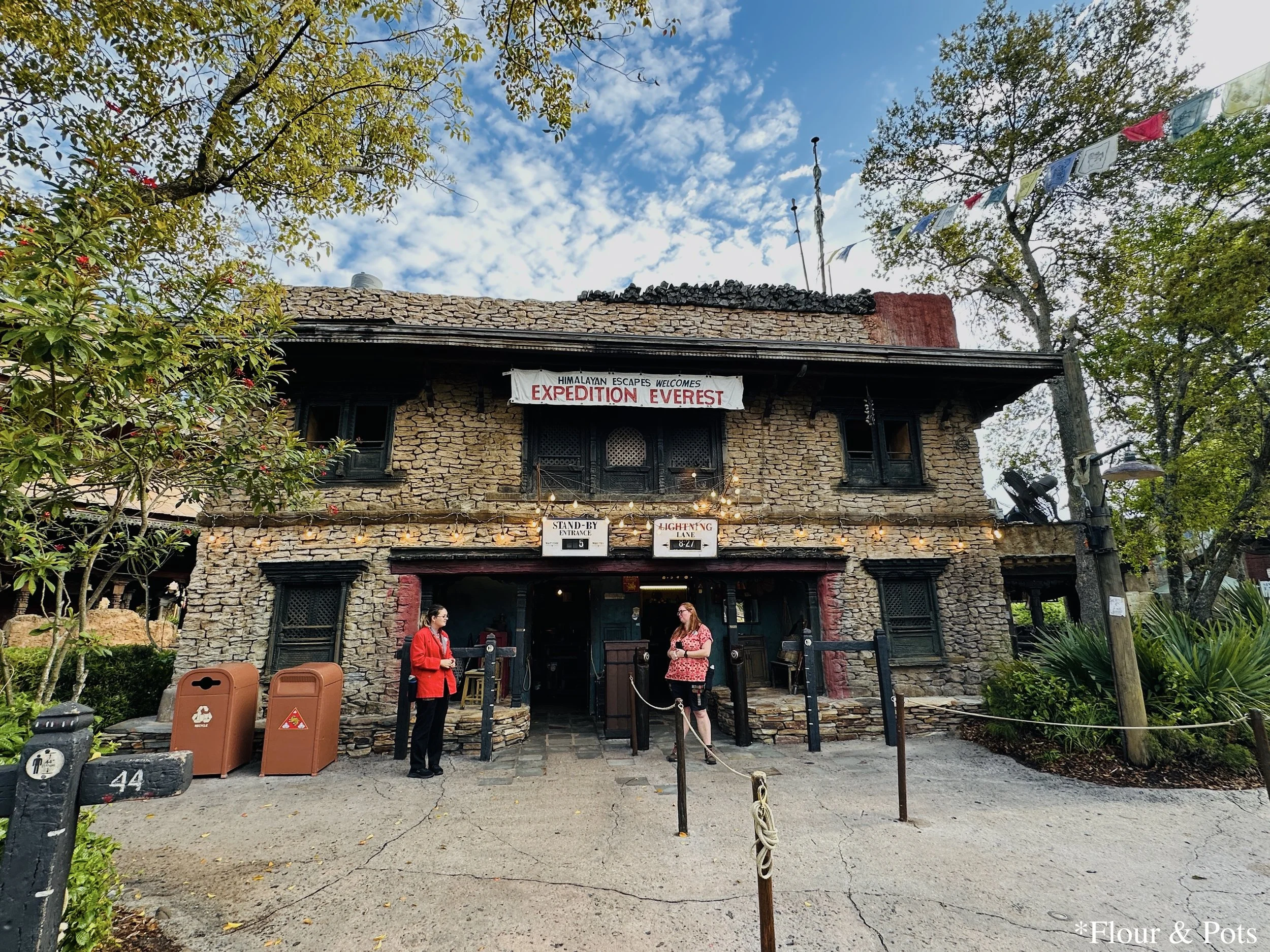 The entrance to Expedition Everest at Disney's Animal Kingdom in Orlando, Florida, showing the start of the queue line with themed Himalayan-style architecture and signage.