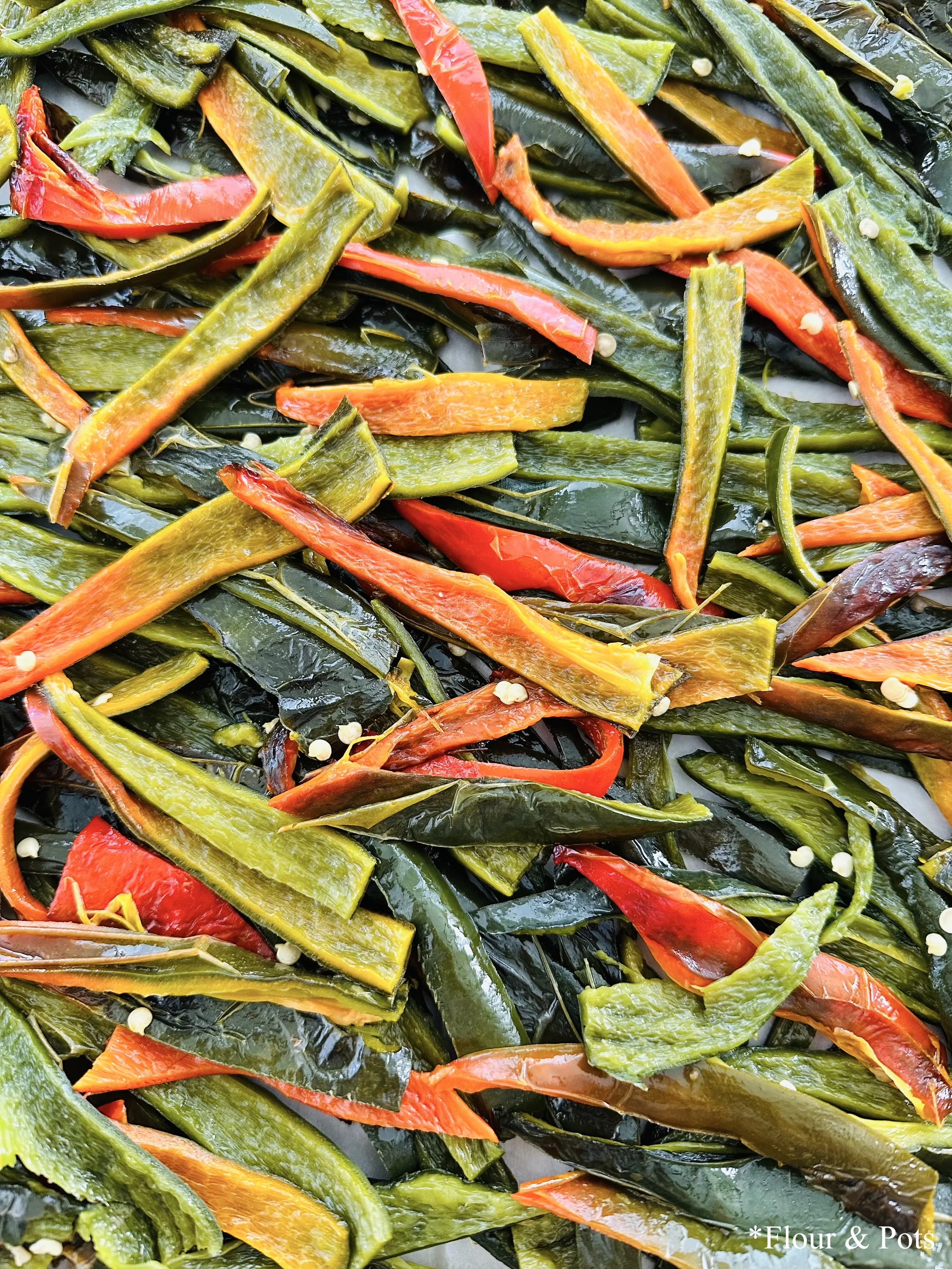 Close-up of roasted poblano peppers sliced into strips, showing tender, smoky flesh.