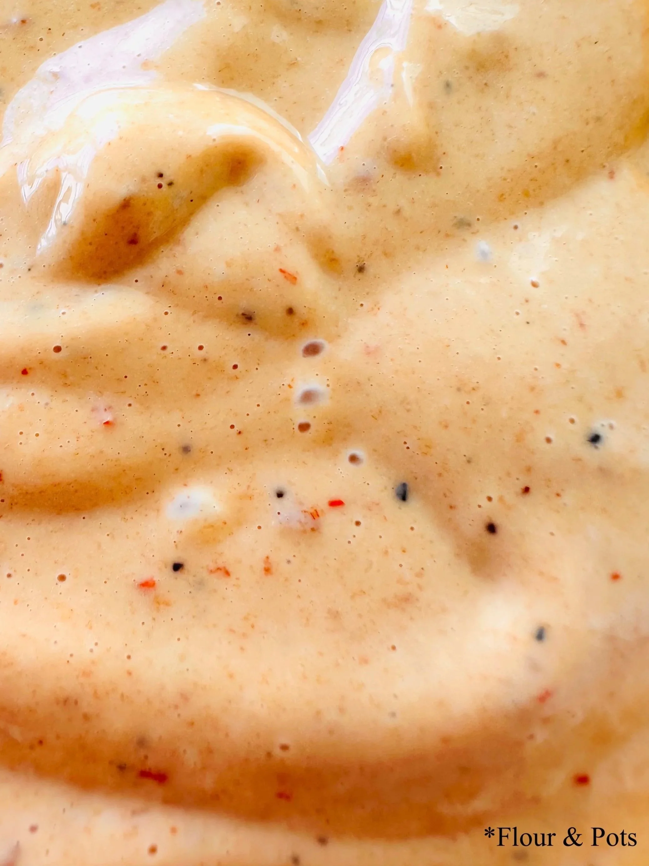 Close-up of creamy strawberry and chipotle aioli, a sweet, smoky sauce made with strawberry jam, lime juice, mayo, and chipotle peppers.
