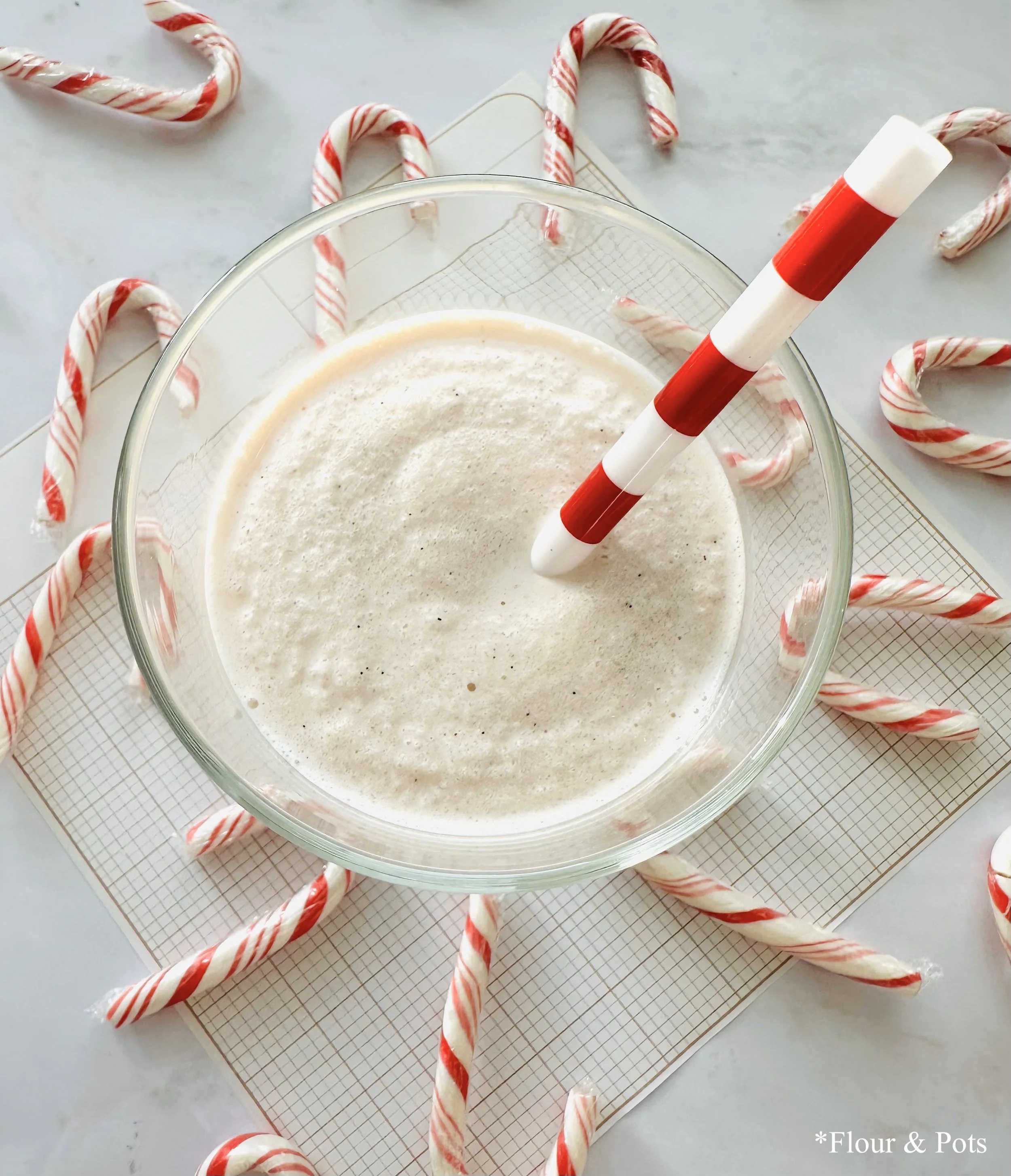 Close-up of a peppermint candy cane smoothie made with Greek yogurt, showing a creamy texture and crushed candy cane topping.