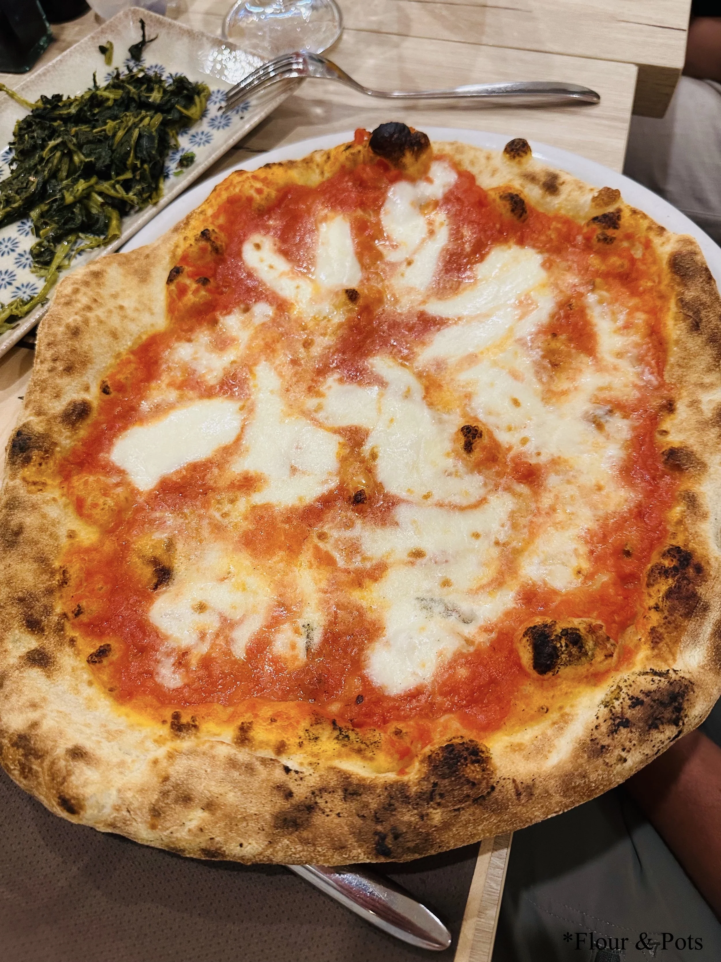 A warm, gooey cheese pizza fresh from La Panetteria in Rome, Italy, with melted cheese bubbling on a golden crust.