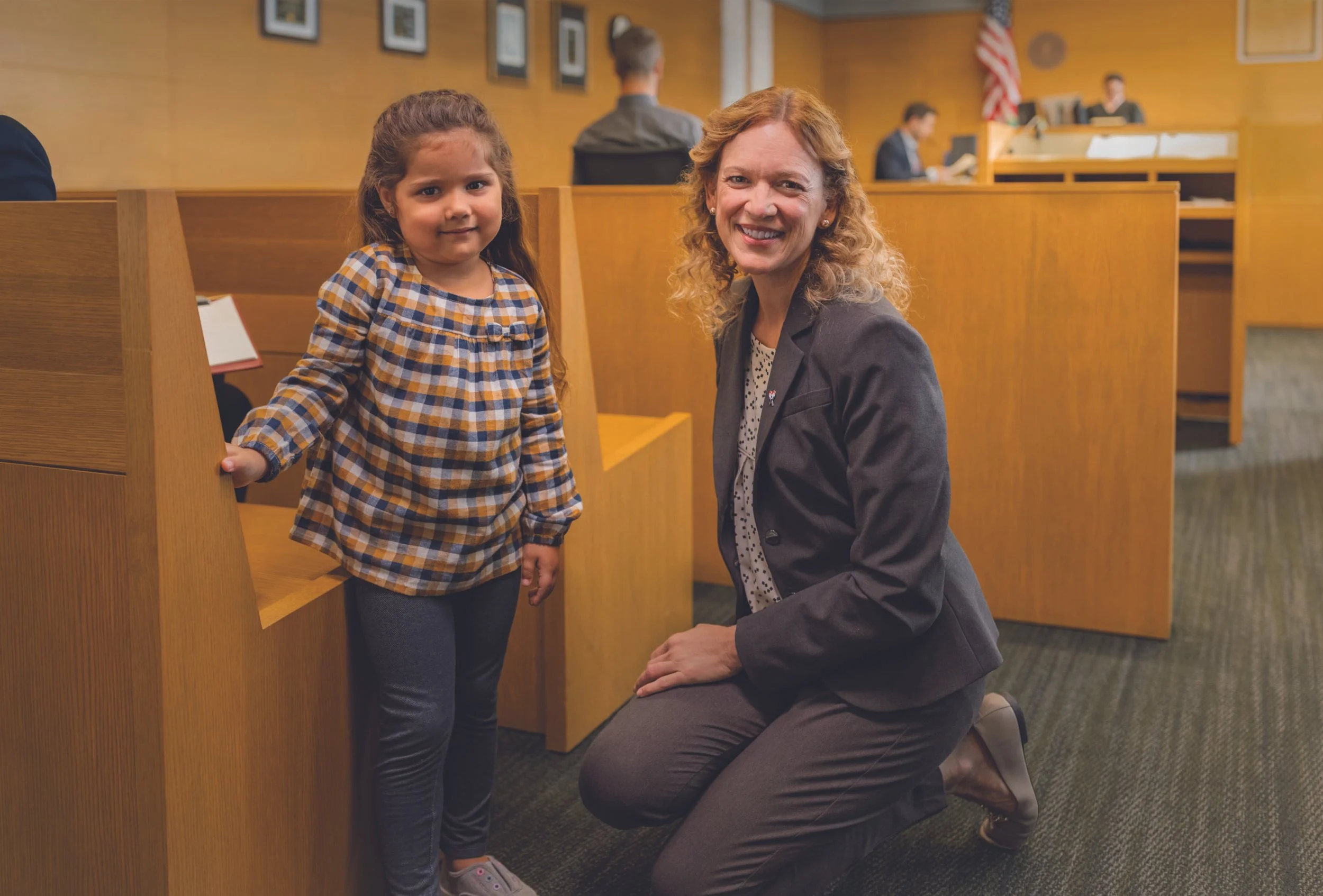 female casa volunteer with young girl in courtroom