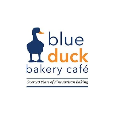Logo of Blue Duck Bakery Cafe featuring a blue duck and text that reads 'blue duck bakery cafe' and 'Over 20 Years of Fine Artisan Baking.'