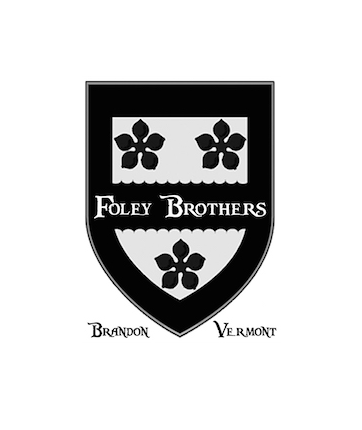 A black and white shield with three flowers and the words "Foley Brothers" in the center, and the names "Brandon" and "Vermont" below.