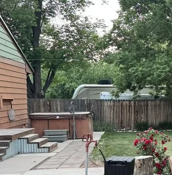 Backyard with patio, hot tub, garden, and wooden fence