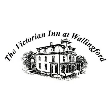 Logo of The Victorian Inn at Wallingford featuring an illustration of a Victorian-style inn with trees, and the inn's name curved above.