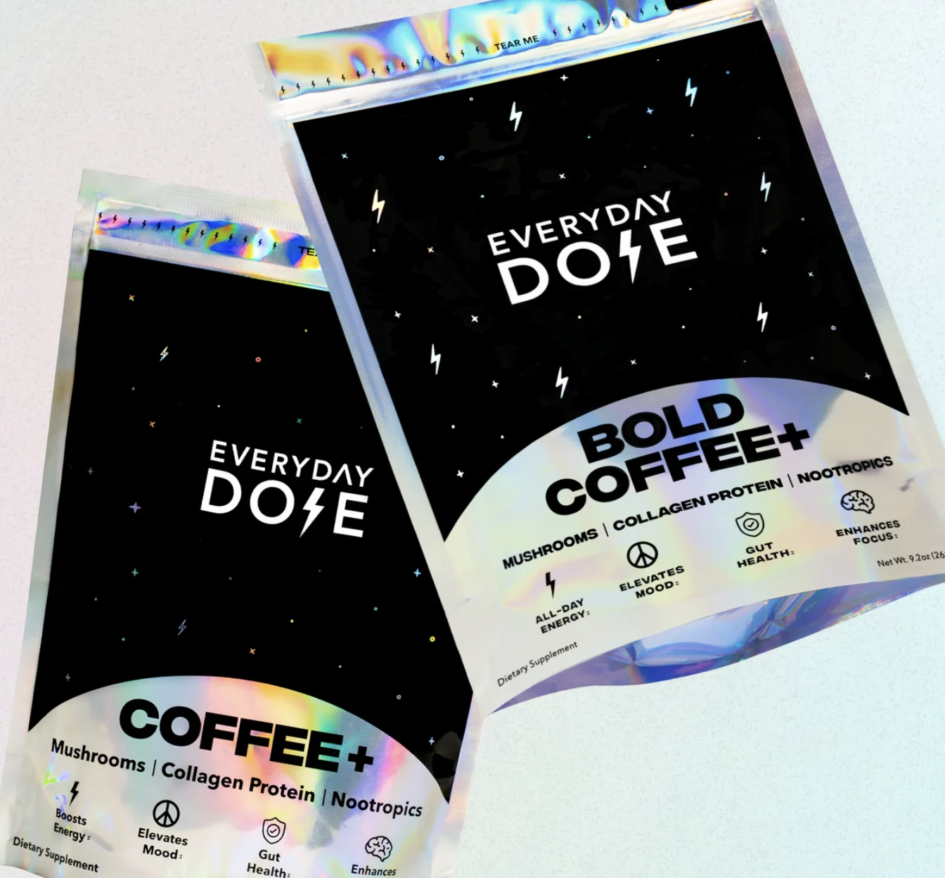 Two packages of coffee with holographic accents, labeled 'Everyday Dose' and 'Bold Coffee+', featuring icons and text about mushrooms, collagen protein, nootropics, and health benefits.