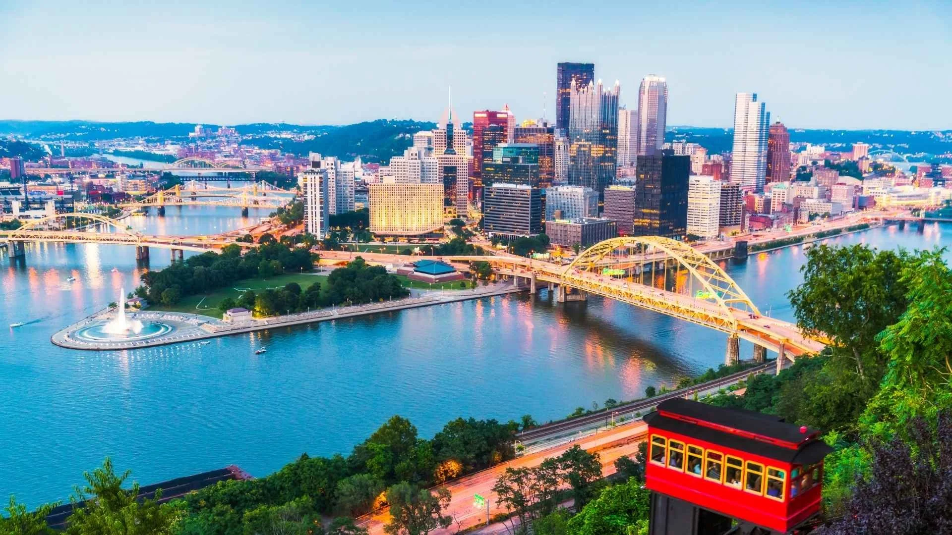 Pittsburgh, PA skyline at dusk with the three rivers and Fort Pitt Bridge — a popular base for travel trailer rentals in western Pennsylvania