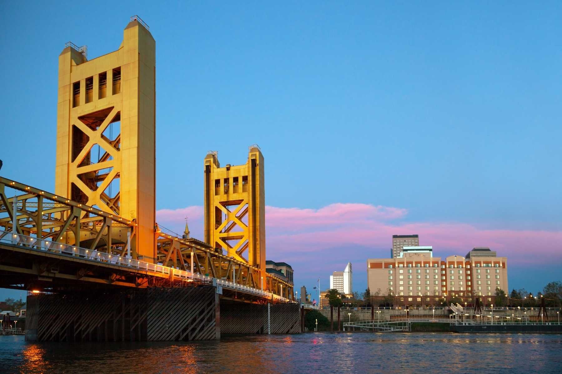 Sacramento's golden Tower Bridge lit at dusk over the Sacramento River, a starting point for travel trailer rentals in Sacramento, CA
