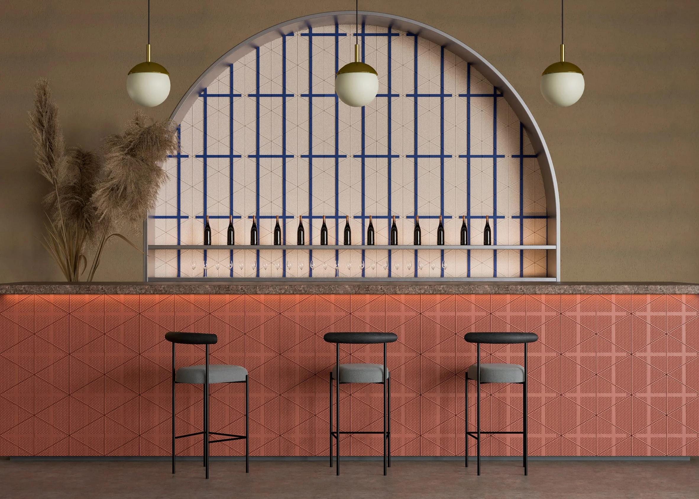 Modern bar interior with three stools, decorative wall with geometric patterns, wine bottles on shelf, two hanging globe lights, and pampas grass.