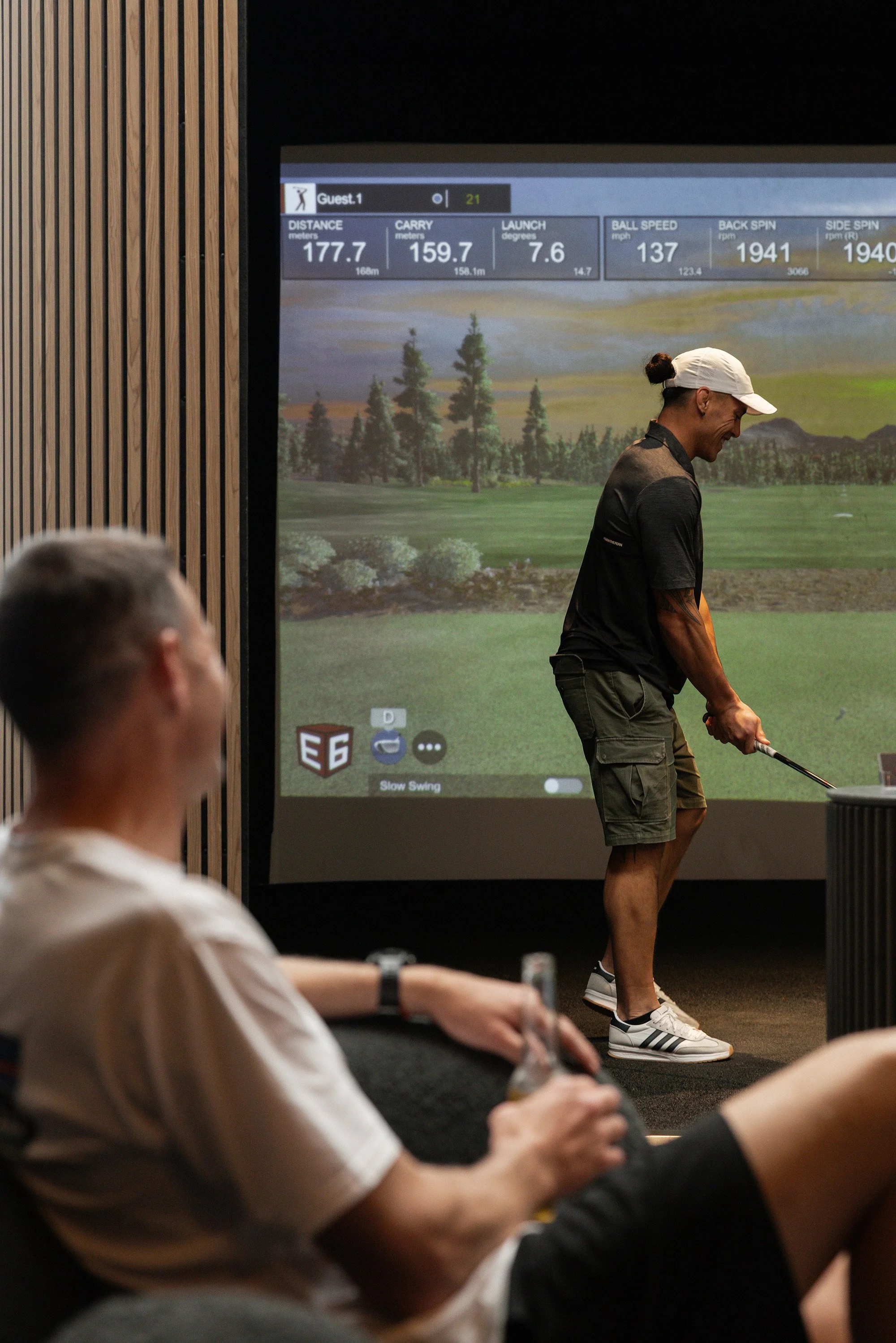 Guests enjoying indoor golf and drinks at Bunker Golf in Mount Maunganui