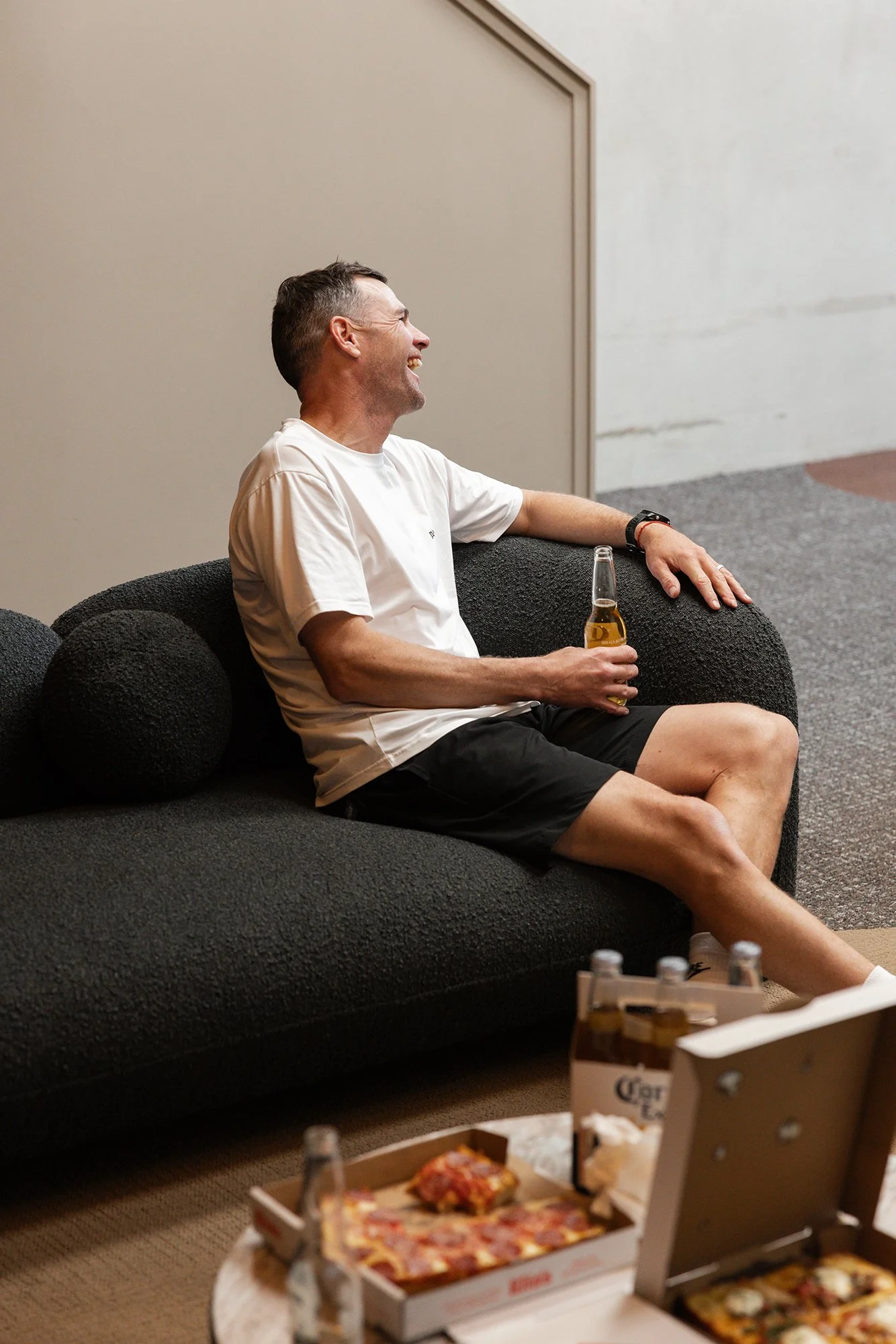 Guest enjoying pizza and drinks during a social indoor golf function at Bunker Golf in Mount Maunganui