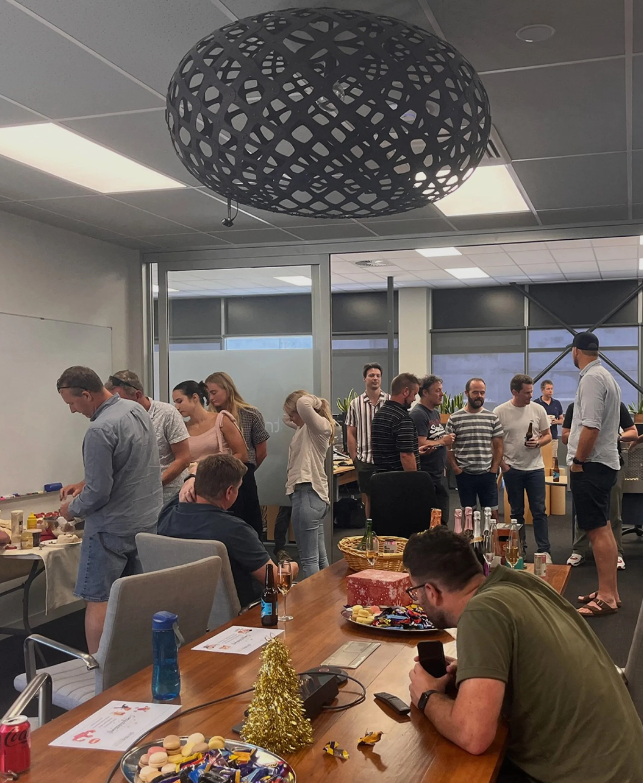 Our Team - Strata Group - New Zealand's Best Engineers | Office party with people socializing around tables with food and drinks.