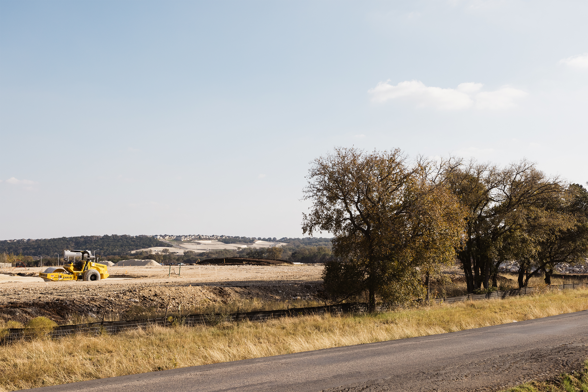 Rural landscape with construction equipment and trees