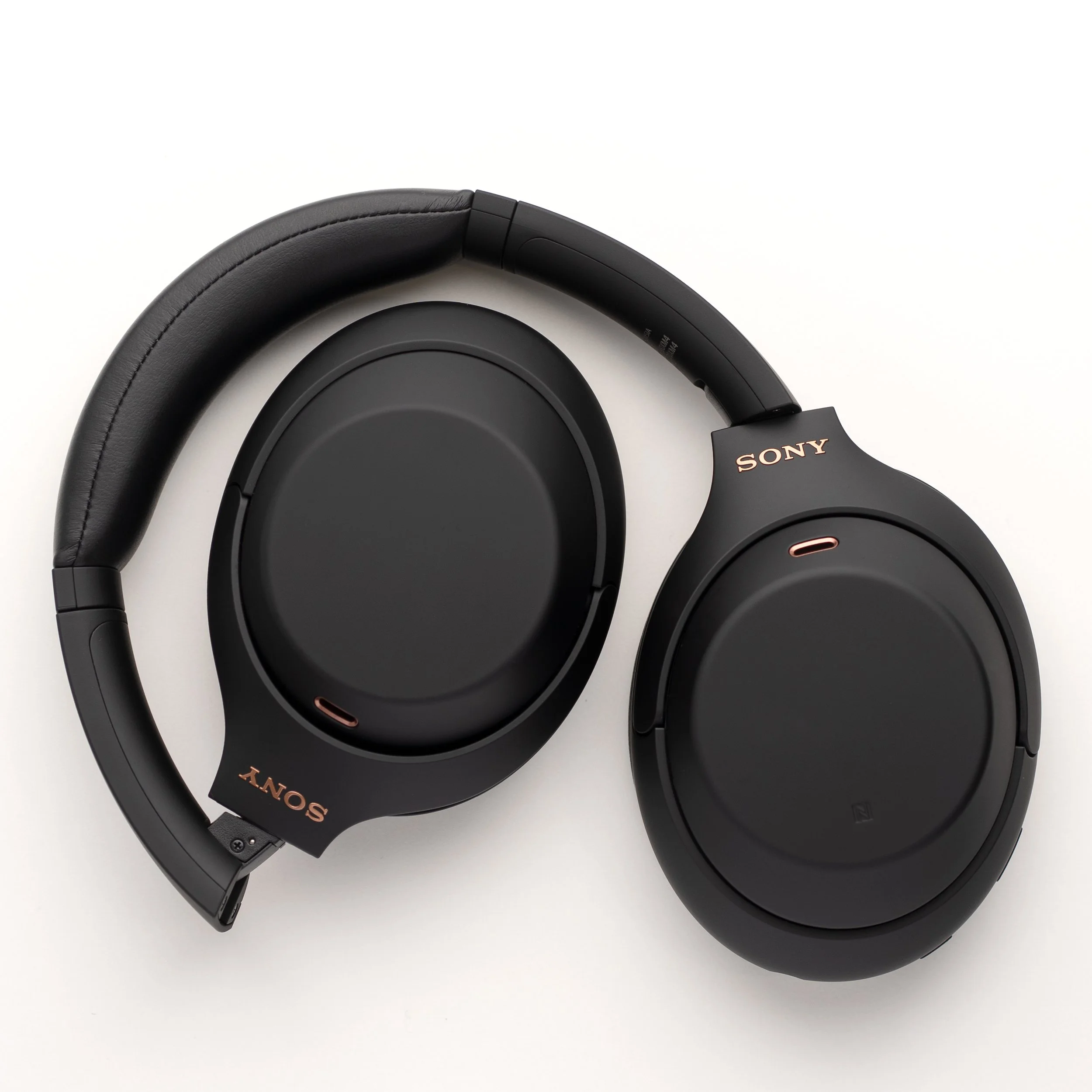 Black Sony over-ear headphones on a white background, showing the headband and ear cups.