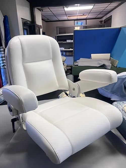 White upholstered chair in Cornerstone fabric with padded armrests and adjustable frame in a workshop setting