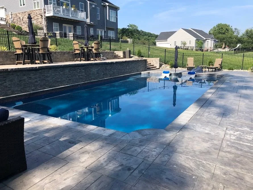 Gunite pool with raised wall, waterfalls, and tanning ledge in Mt. Airy, MD.