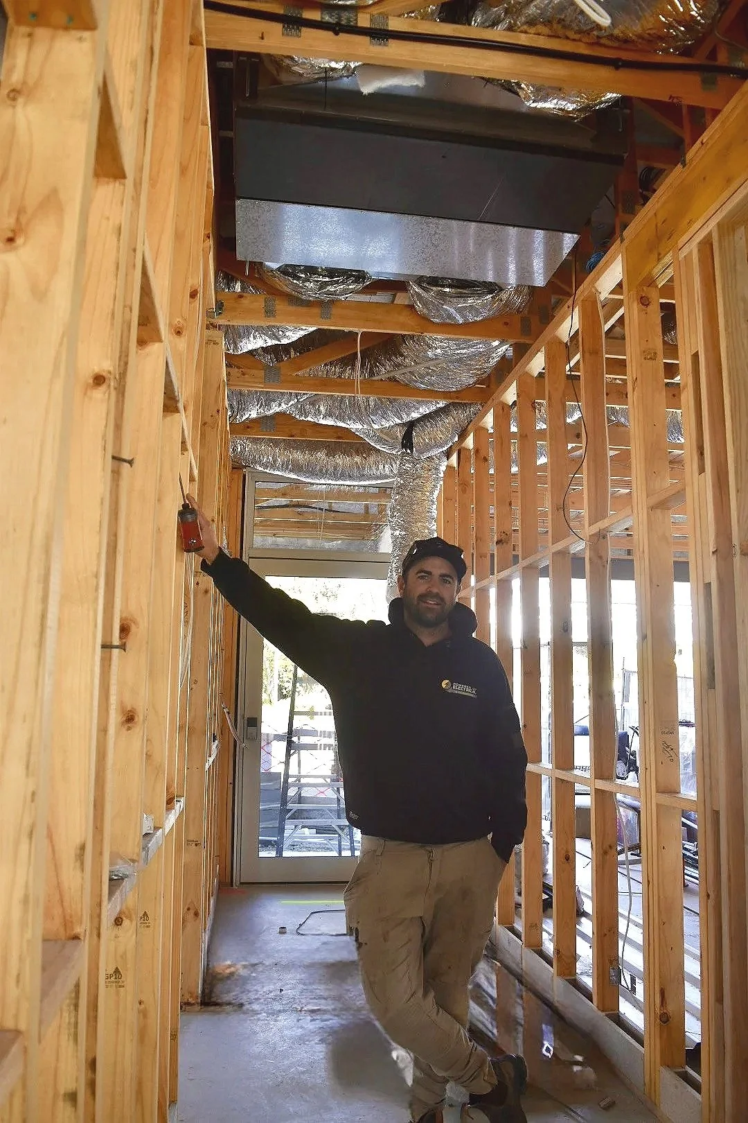 Powered Up Electrical director Joel in front of ducted system