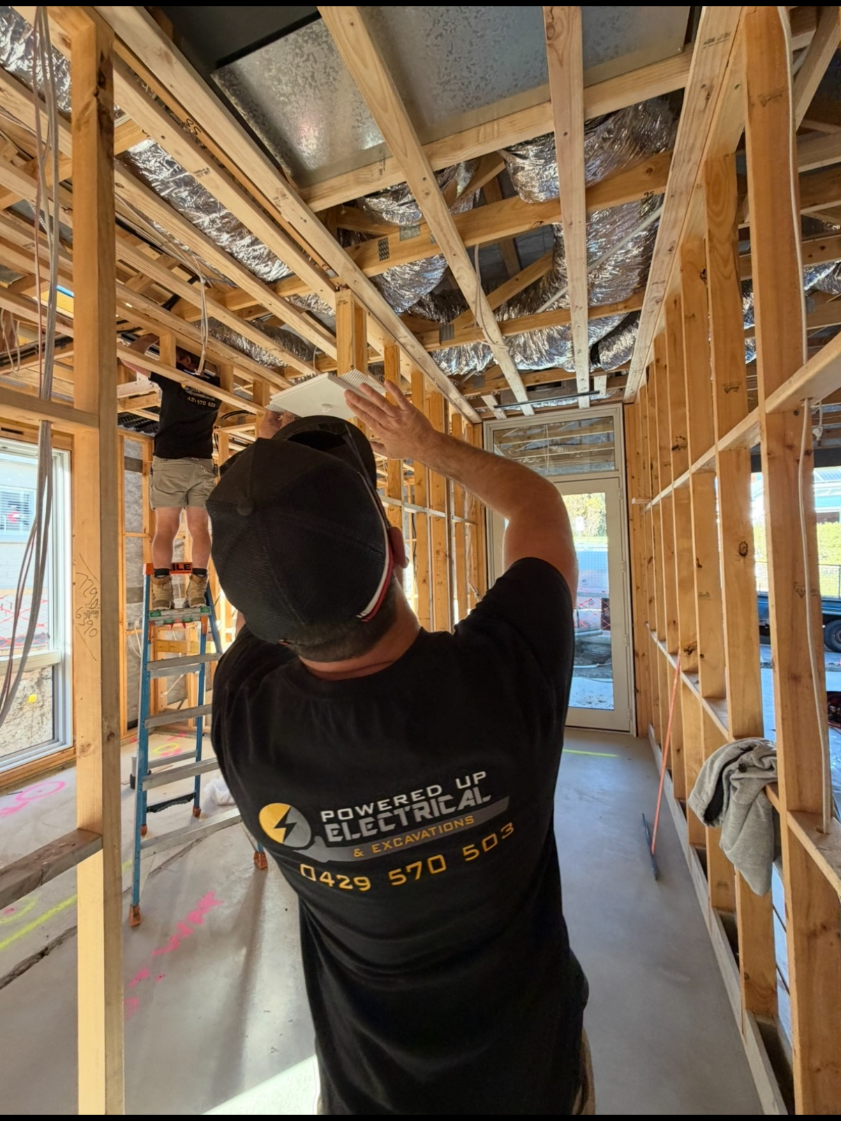 Electrician installing a ducted heat pump system in a new construction build.