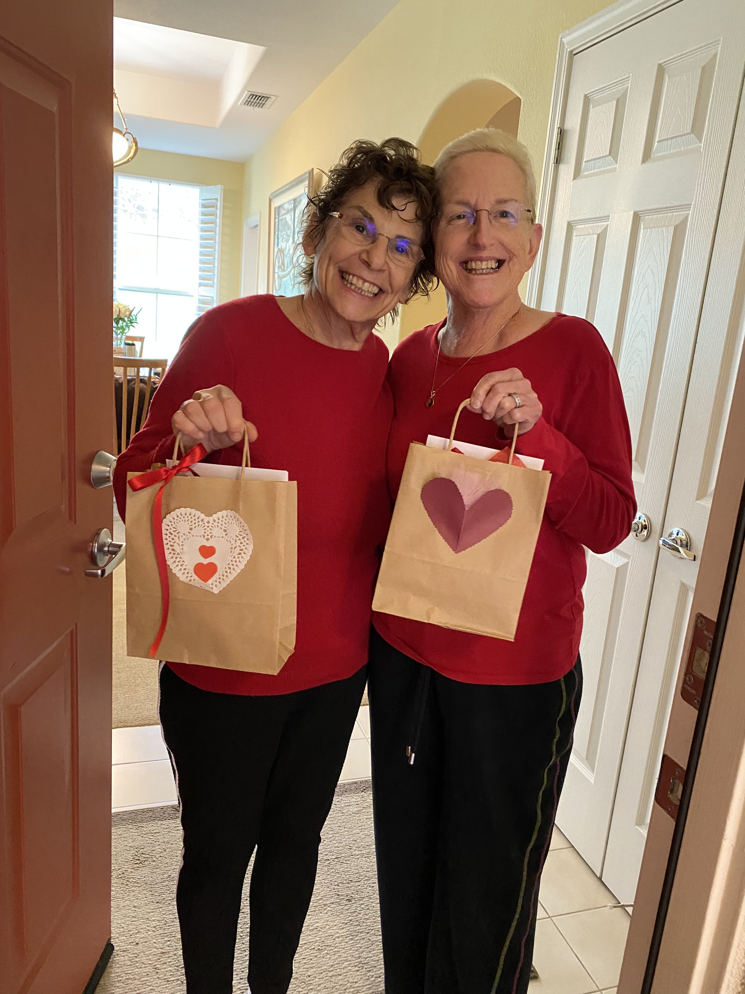Karen Nemark and Deb Mayer receiving a valentine goodie bag from the club