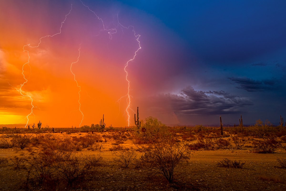 Schism in the Sky:
Two forces clash at twilight — one forged in fire, the other in fury. As the desert sky fractures between beauty and chaos, the silence is split by thunder and light. In that moment, nature doesn’t choose a side. It simply breaks a