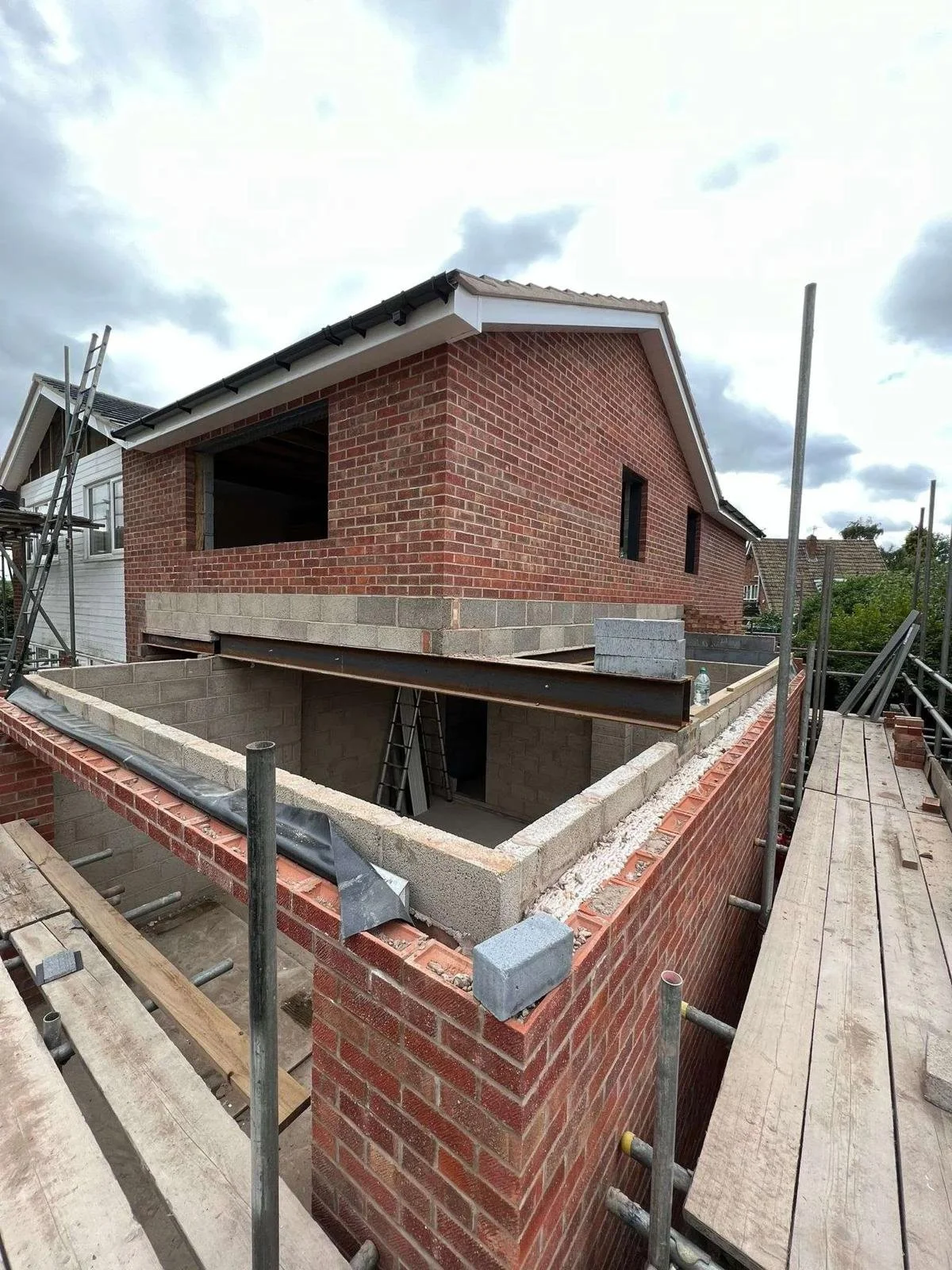 Two storey extension with brick and scaffolding