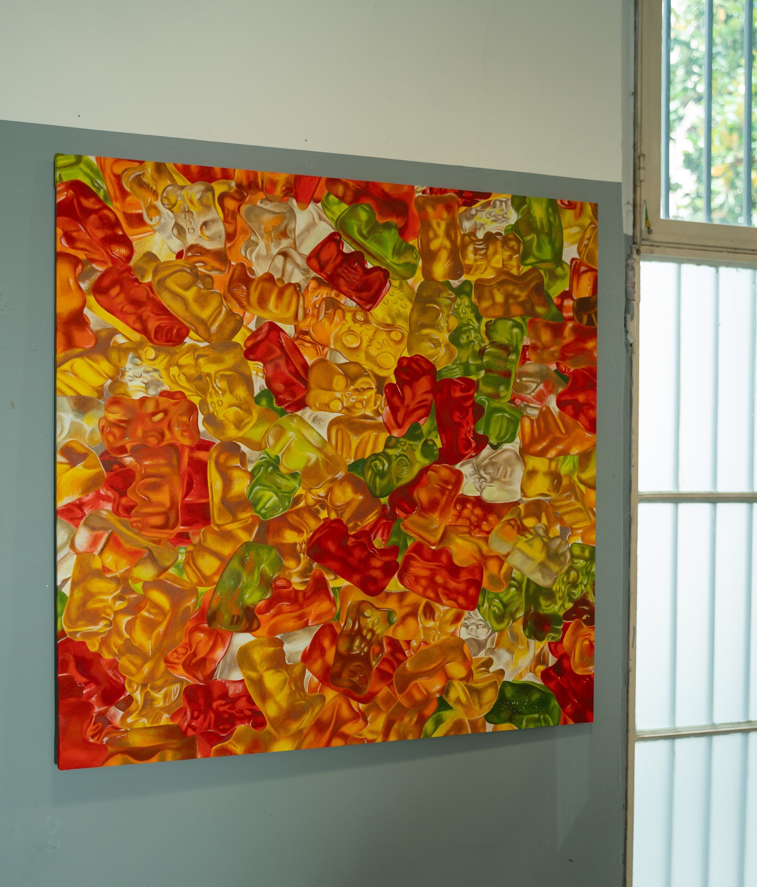 Una finestra con una vetrata decorativa colorata, composta da pezzi di vetro colorato in tonalità di rosso, giallo, verde e arancione.