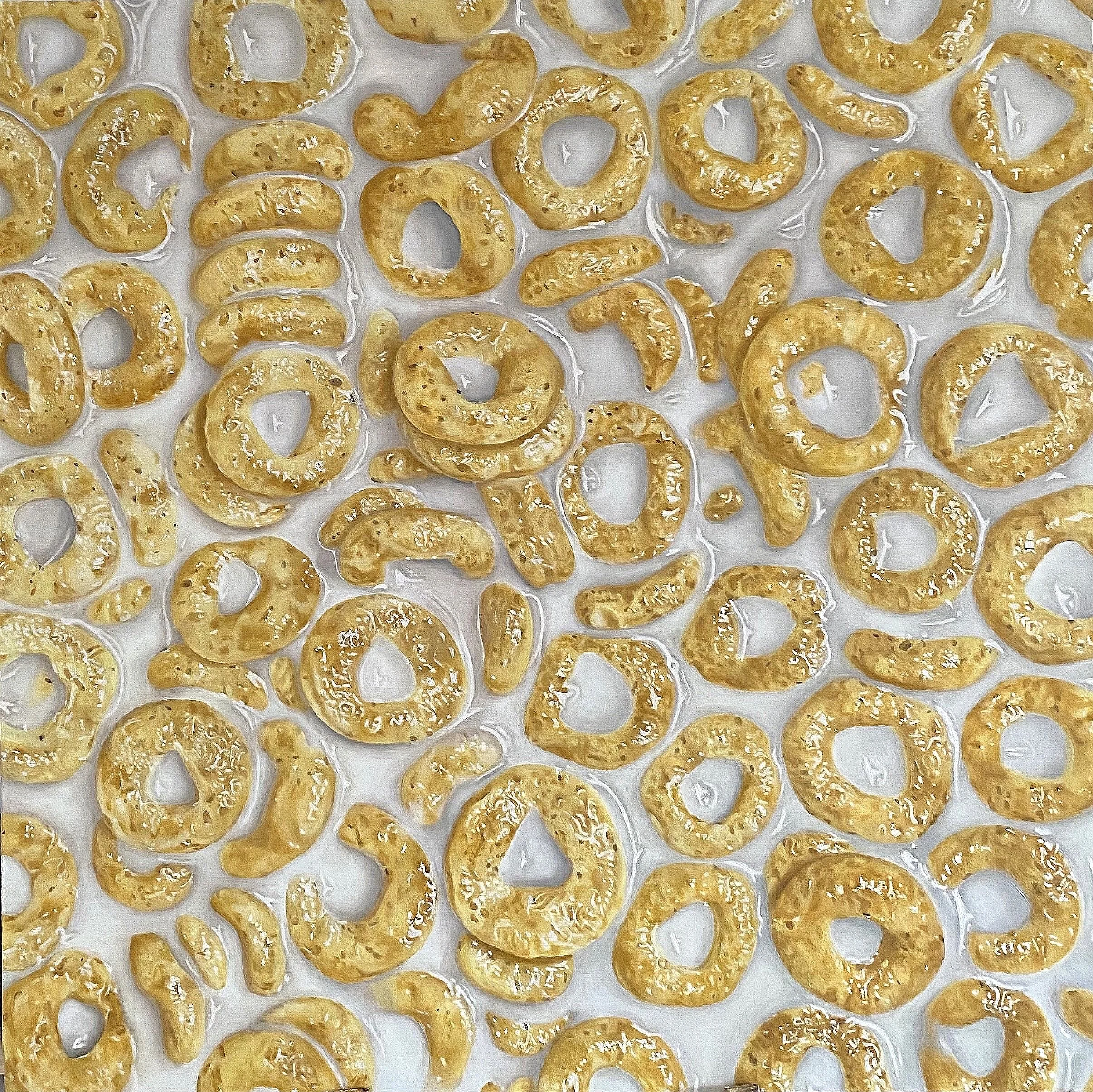 Fette di pasta croccante in forma di anelli dorati disposte su un ripiano.