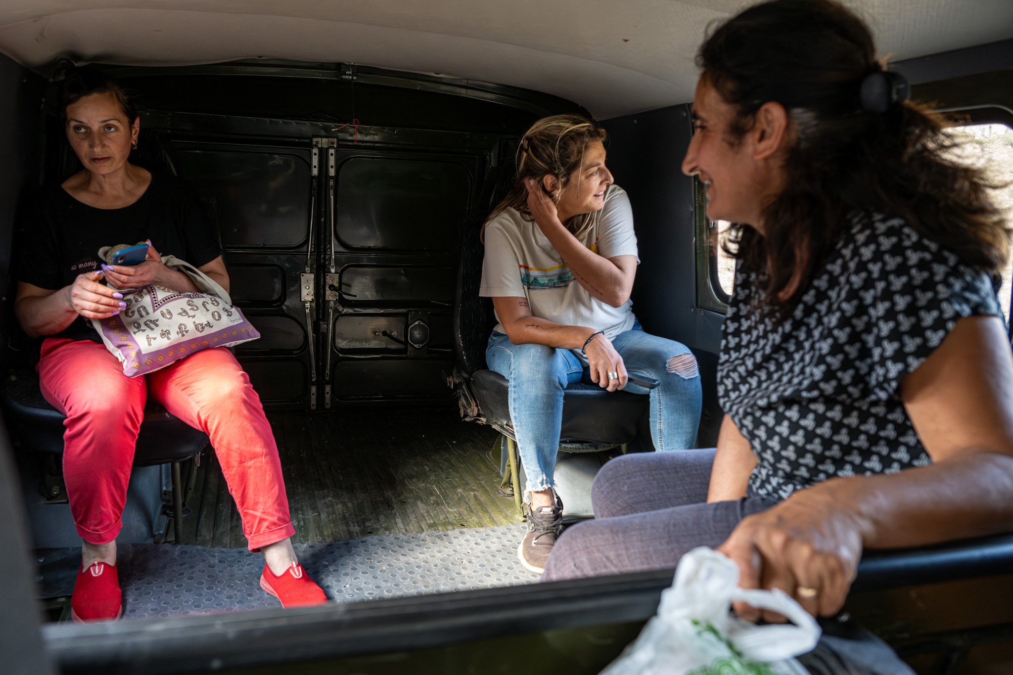 Suriks’s wife, Anoush Harutunyan (front), sits in the back of a car with friends Tarlan and Stacey (back) while en route to a different cave built by Surik that houses canned foods and alcohol.