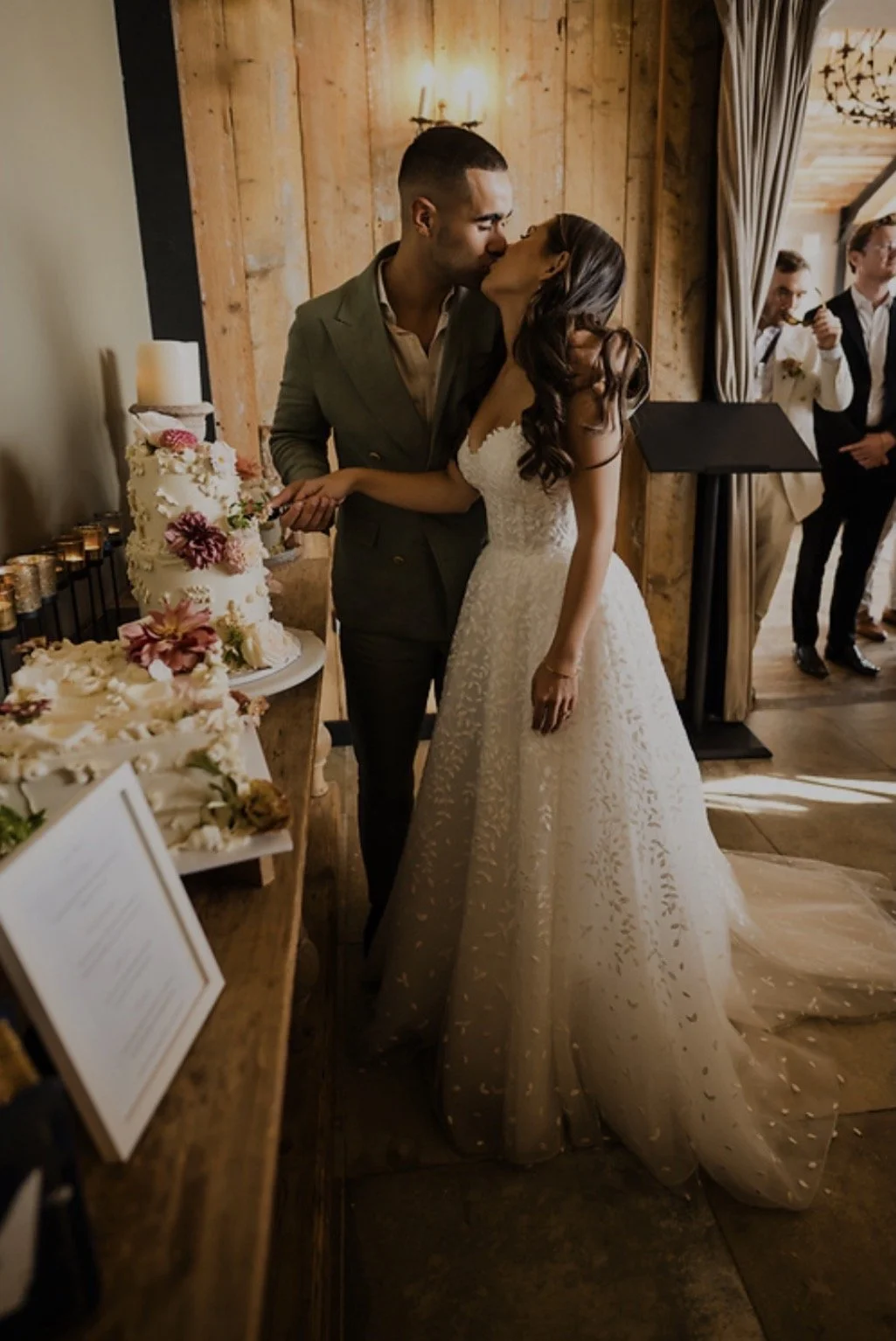 couple kissing and cutting their wedding cakes