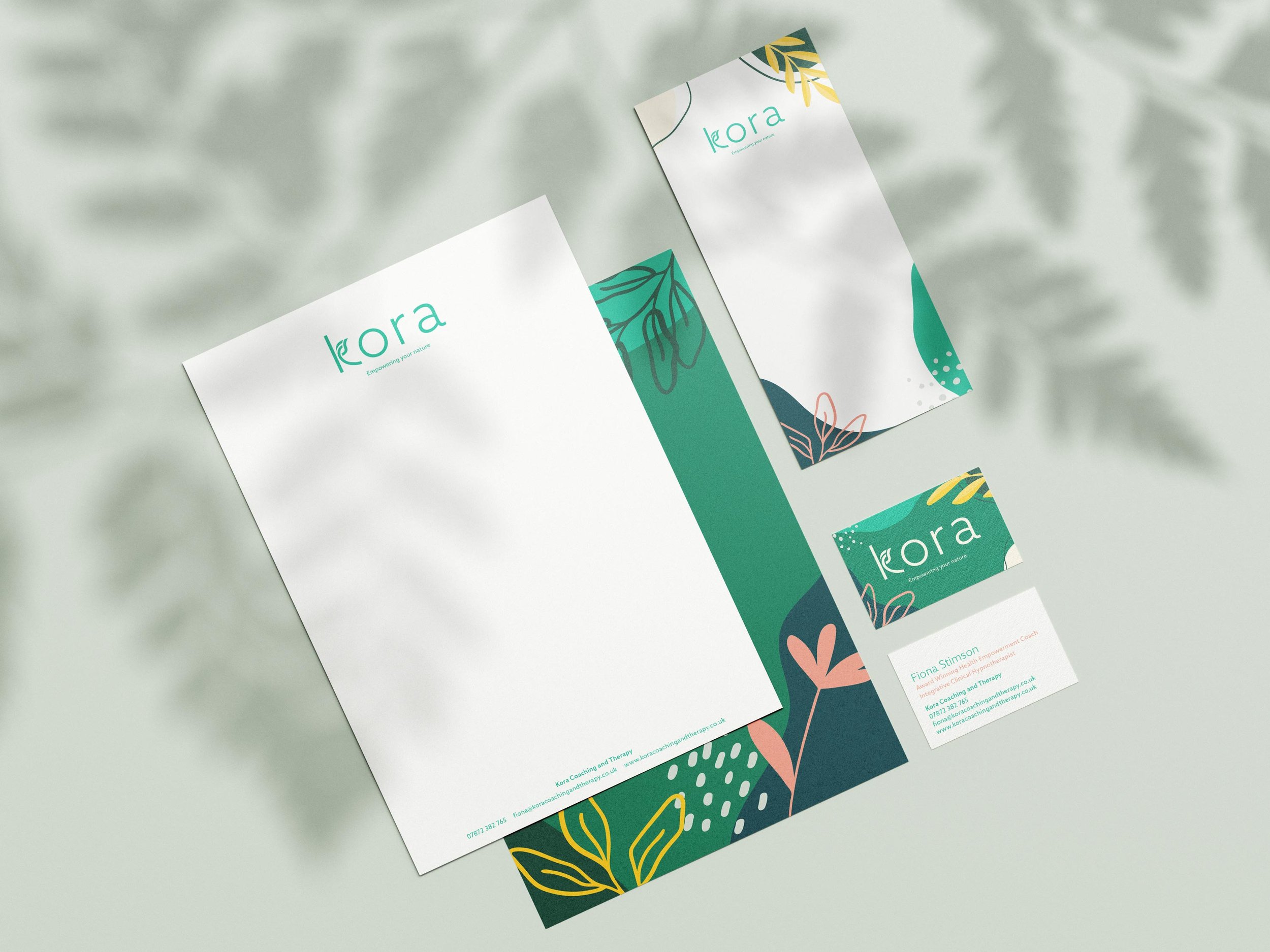 Kora-branded stationery arranged on a neutral background, including headed paper, cards, and business cards.