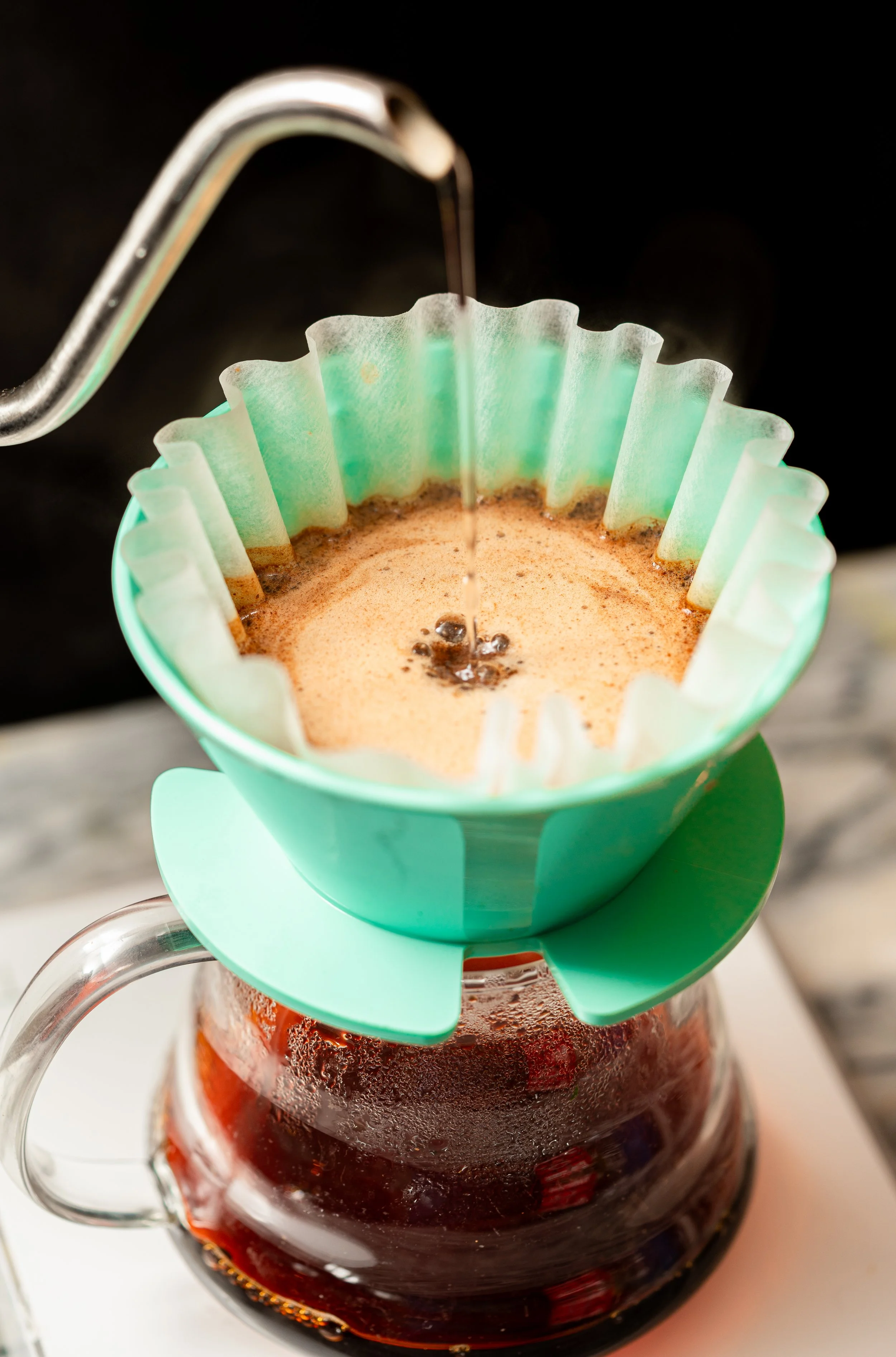 A V60 pour-over coffee maker brewing a fresh cup of coffee inside Sorrel Social.