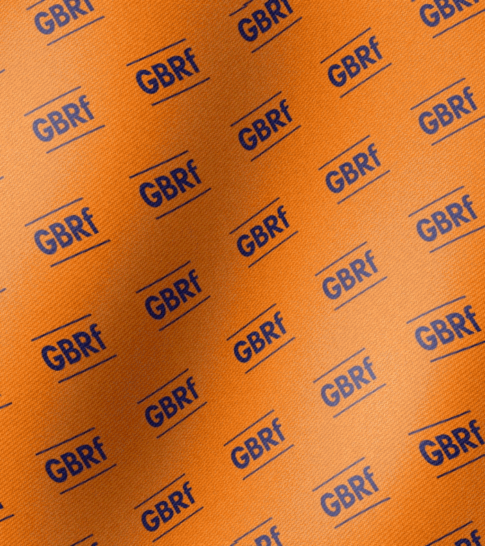 Branded orange cloth waving in the wind, featuring the GB Railfreight (GBRF) logo in bold blue across the front.