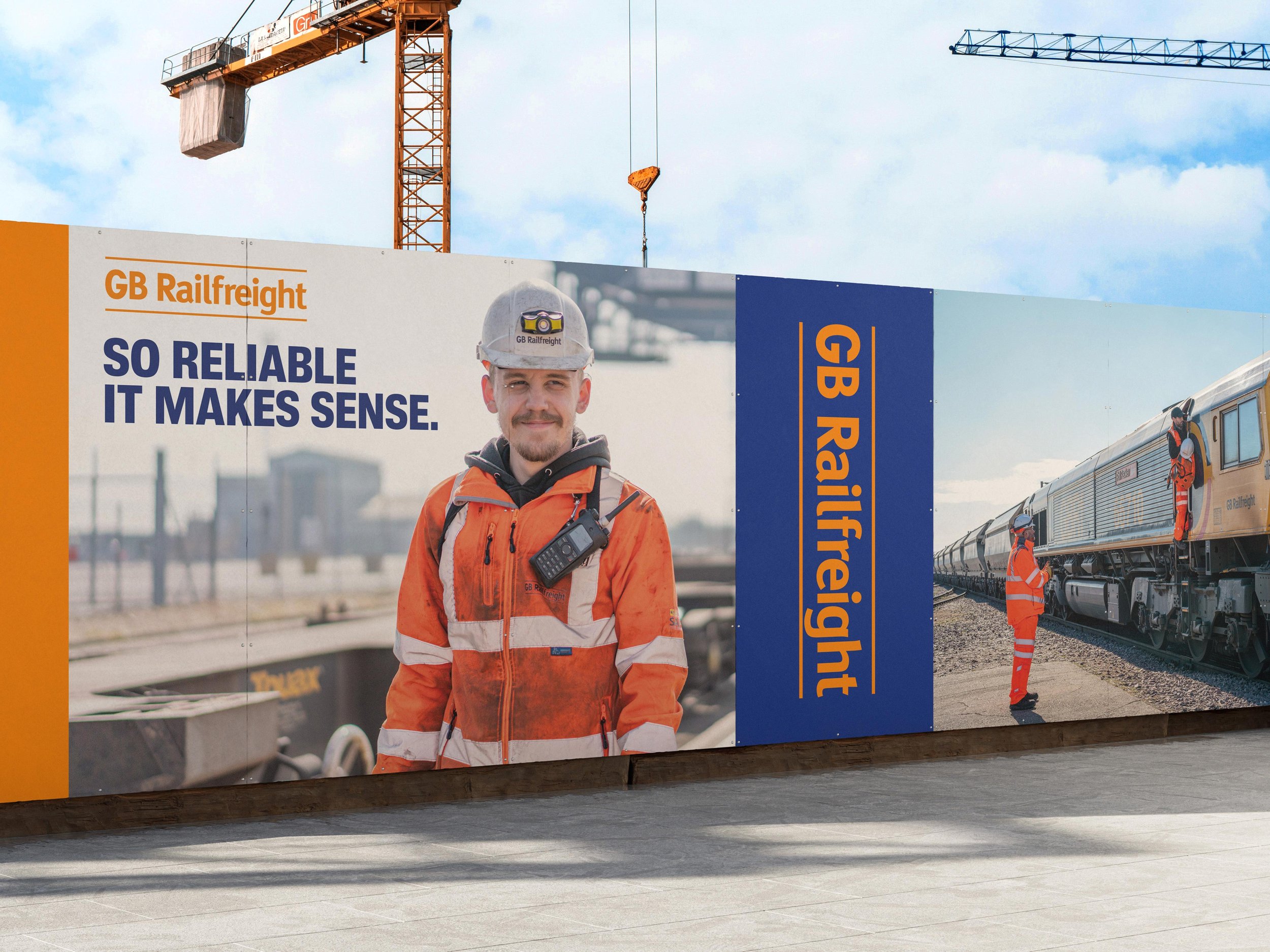 GB Railfreight billboard displayed on a construction site, featuring photos of GB Railfreight engineers and the tagline ‘So reliable it makes sense.’